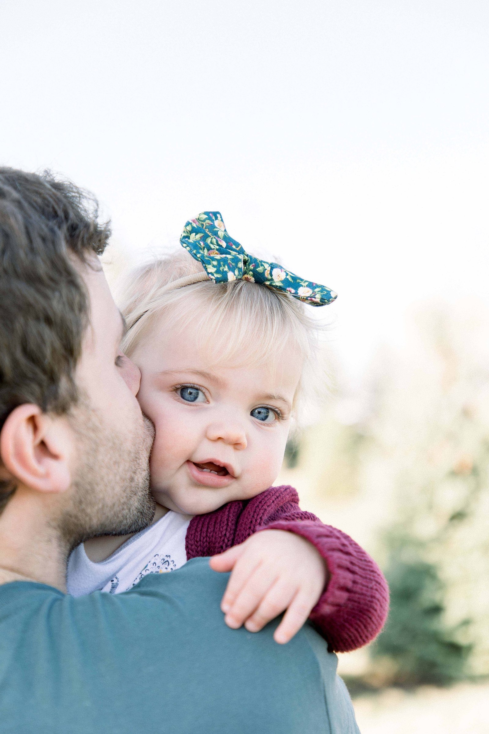 Portrait of father holding baby girl over his should, giving her a kiss on the cheek. Niagara family photographer, Niagara family photography, Niagara portrait photographer, Niagara portrait photography.