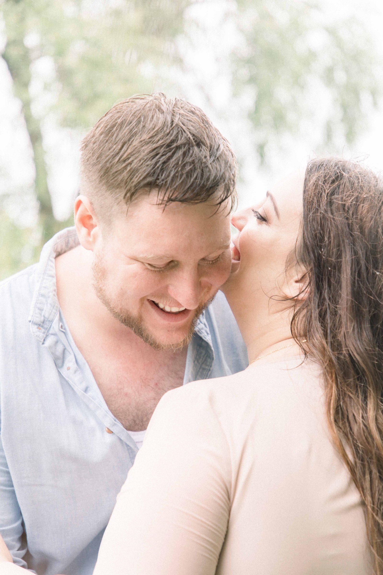Portrait of wife telling husband a secret and husband laughing, Niagara Portrait Photographer, Niagara Family Photographer, Niagara Motherhood Photography, Beach Portrait Photography, Emily VanderBeek Photography.