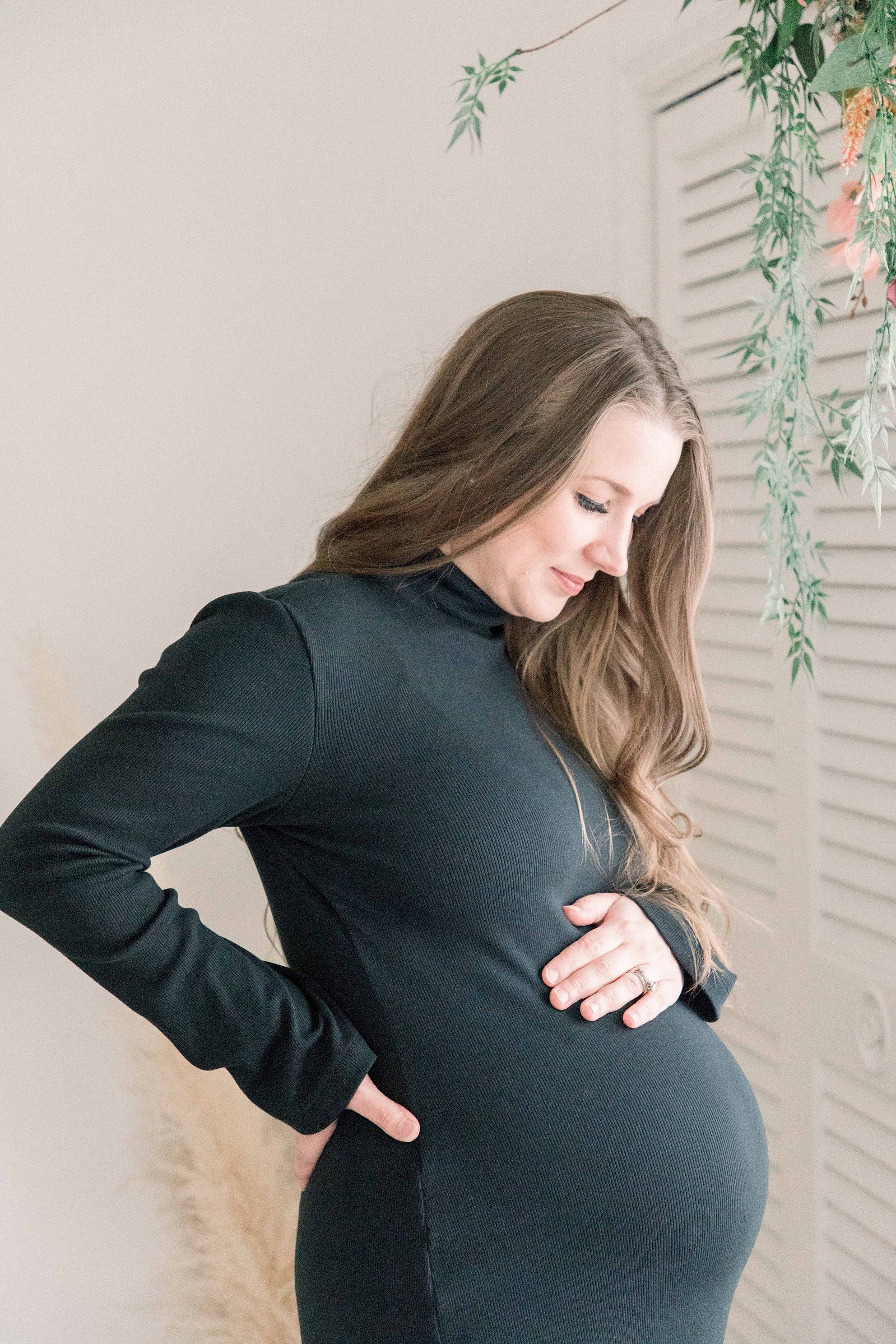 Portrait of a pregnant women holding her belly and looking down at it in a studio. Portrait photography, family photography, motherhood photography, Niagara photographer, Niagara family photography, Vankleek Hill family photography. Emily VanderBeek Photo