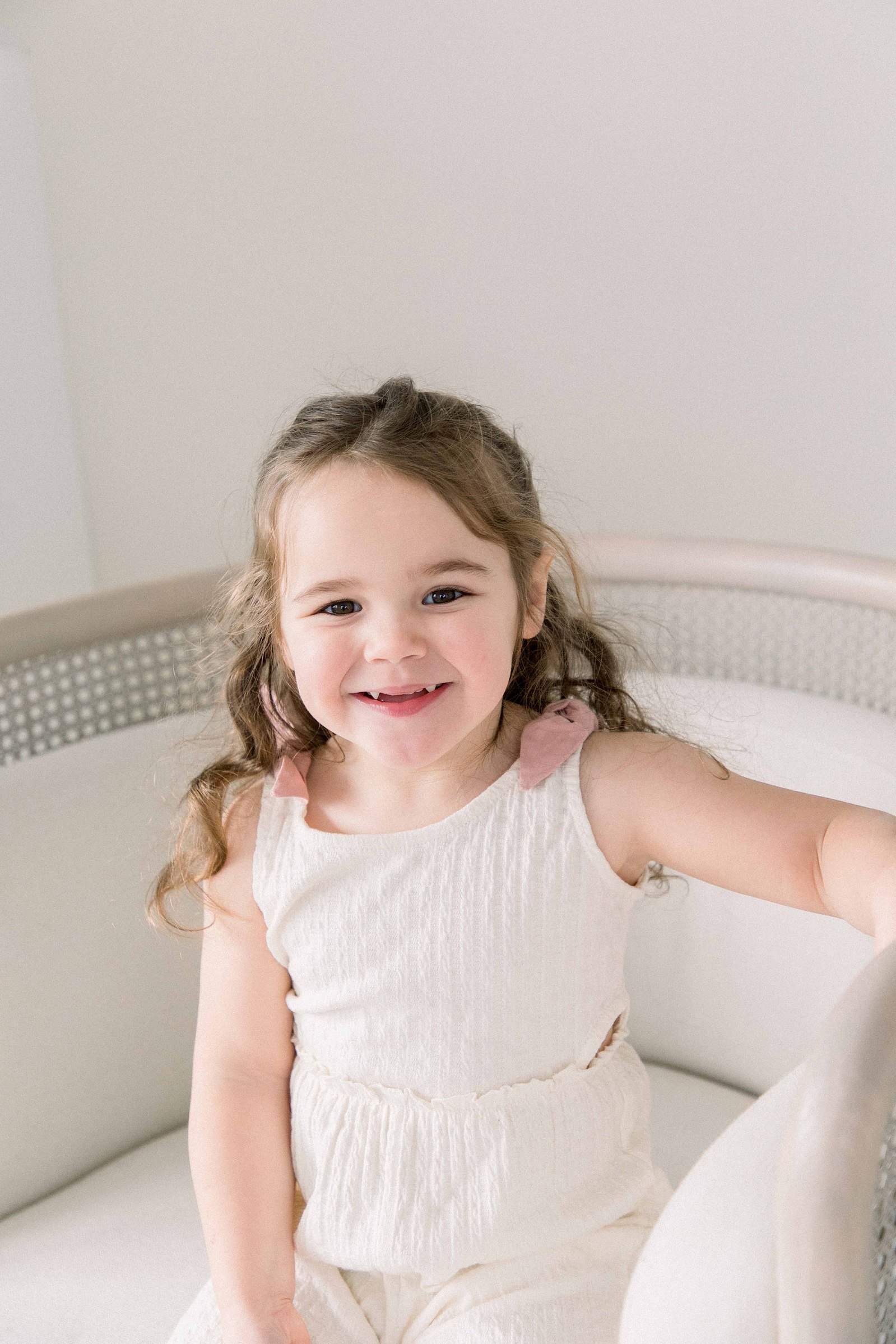 Portrait of young girl sitting in a chair at a studio. Emily VanderBeek Photography. Ottawa family photographer. Candid photography.