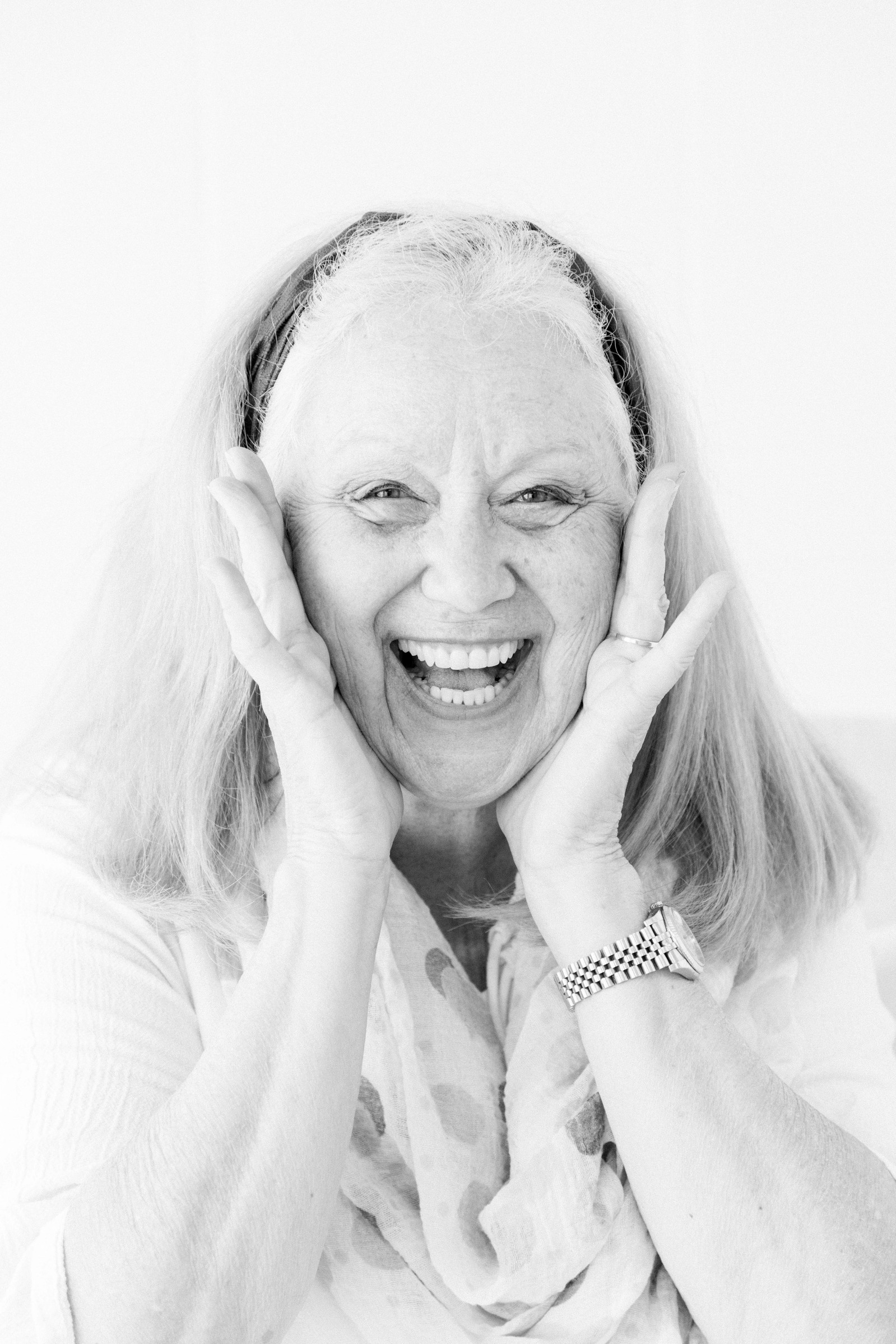 Black and white close up portrait of woman holding her face and laughing. Emily VanderBeek Photography, branding photography, portrait photography, Niagara portrait photographer, Niagara branding photographer.