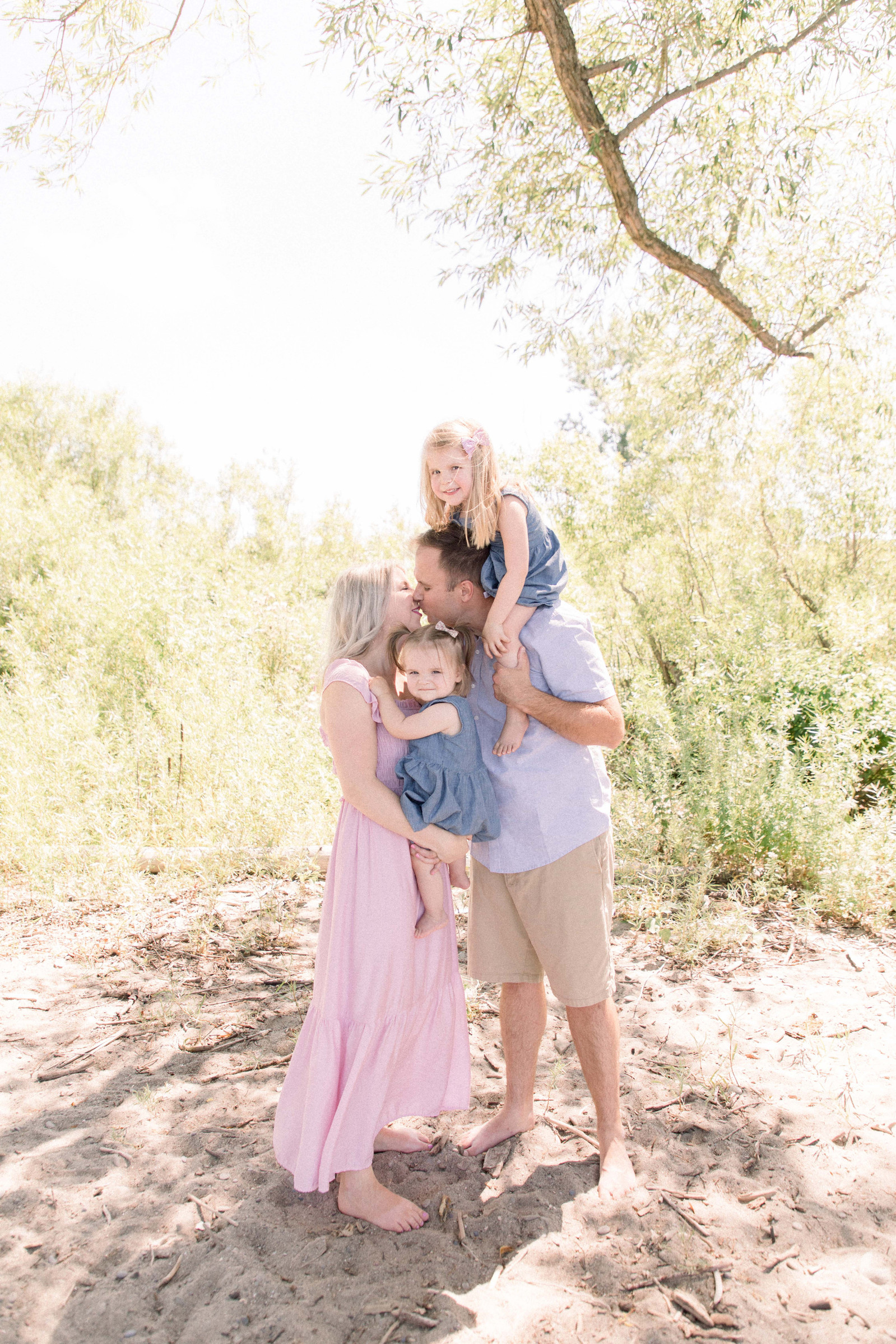 Portrait of family hugging each other on the beach. Niagara family photographer, Niagara portrait photographer, Niagara motherhood photographer, candid photography, light & airy photography, Emily VanderBeek Photography.