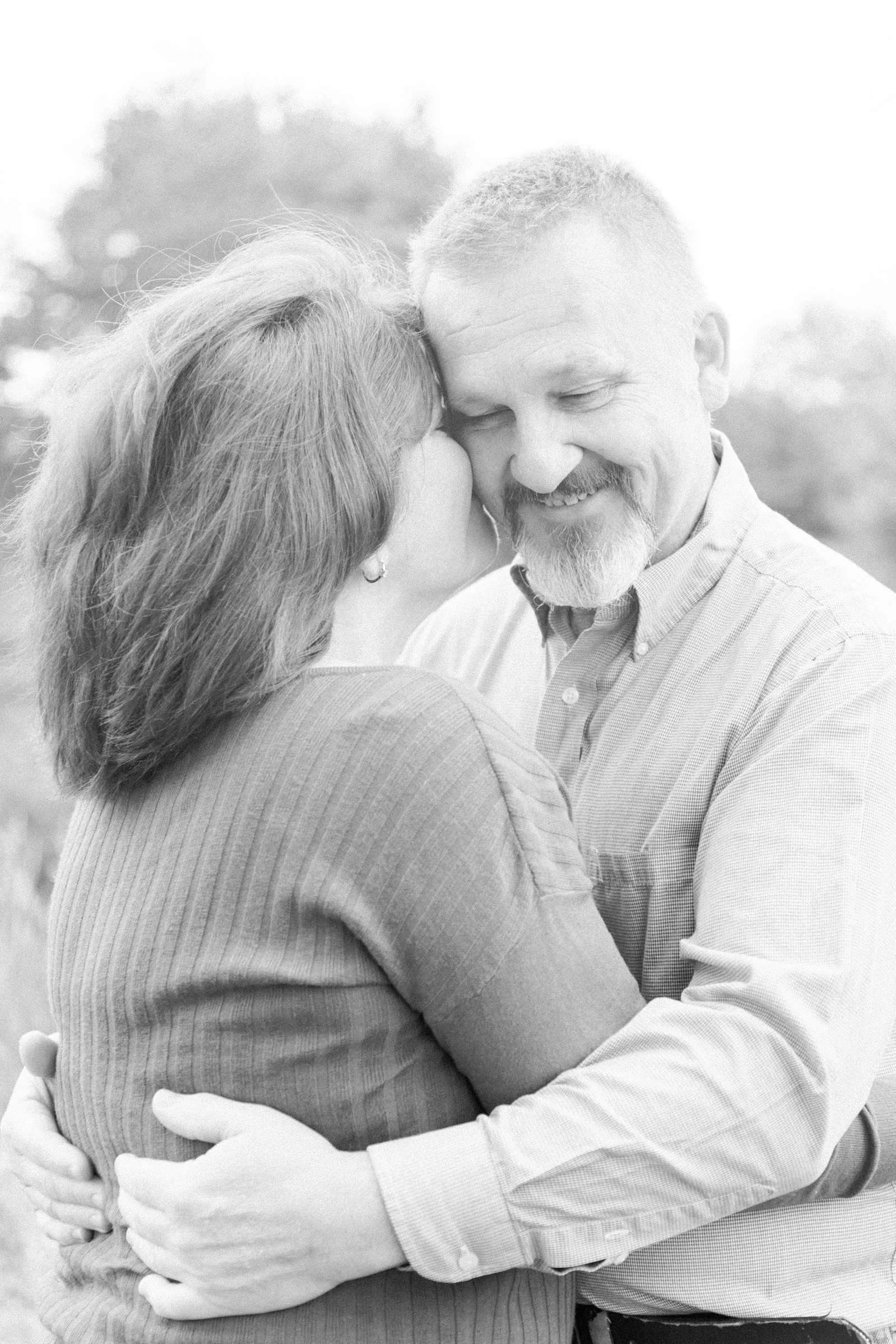 Black and white photo of couple, woman kissing man on the cheek, L'Orignal family photographer, Champlain family photographer, Hawkesbury family photographer, Quebec family photography, Vaudreuil-Soulanges Photographer, Emily VanderBeek Photography.