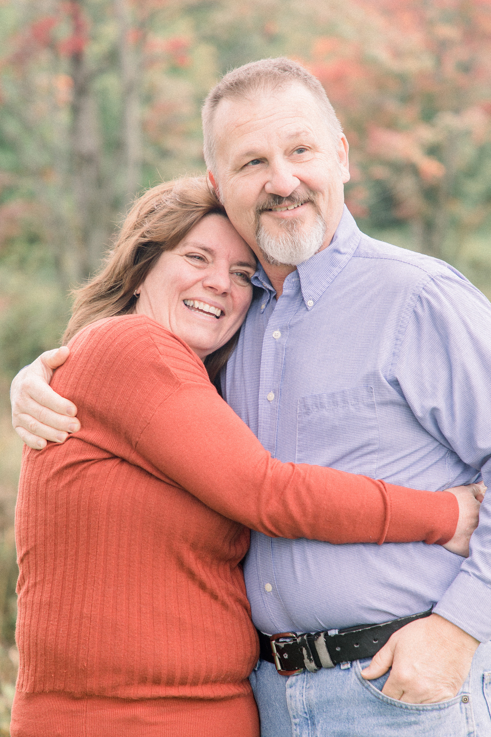 Photo of couple hugging each other smiling off into the distance, L'Orignal family photographer, Champlain family photographer, Hawkesbury family photographer, Quebec family photography, Vaudreuil-Soulanges Photographer, Emily VanderBeek Photography.