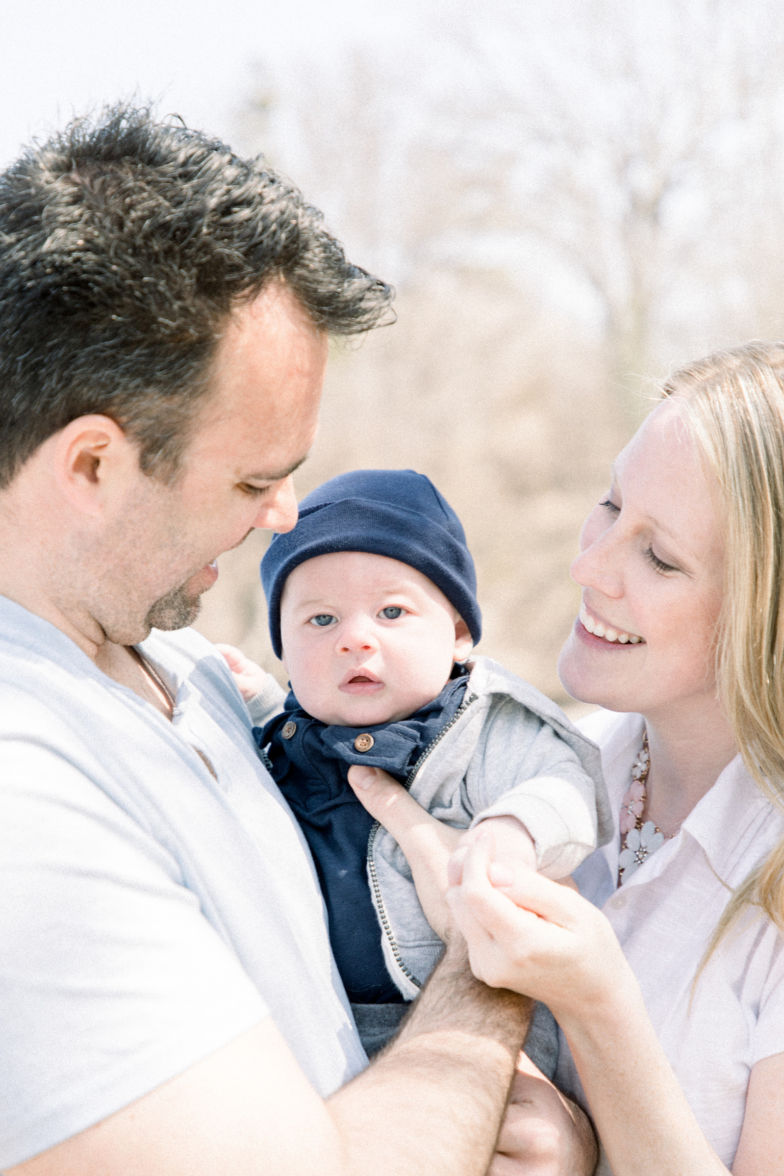 Family portrait of baby boy and his parents, Niagara portrait photographer, Niagara family photographer, family photography, candid photography.