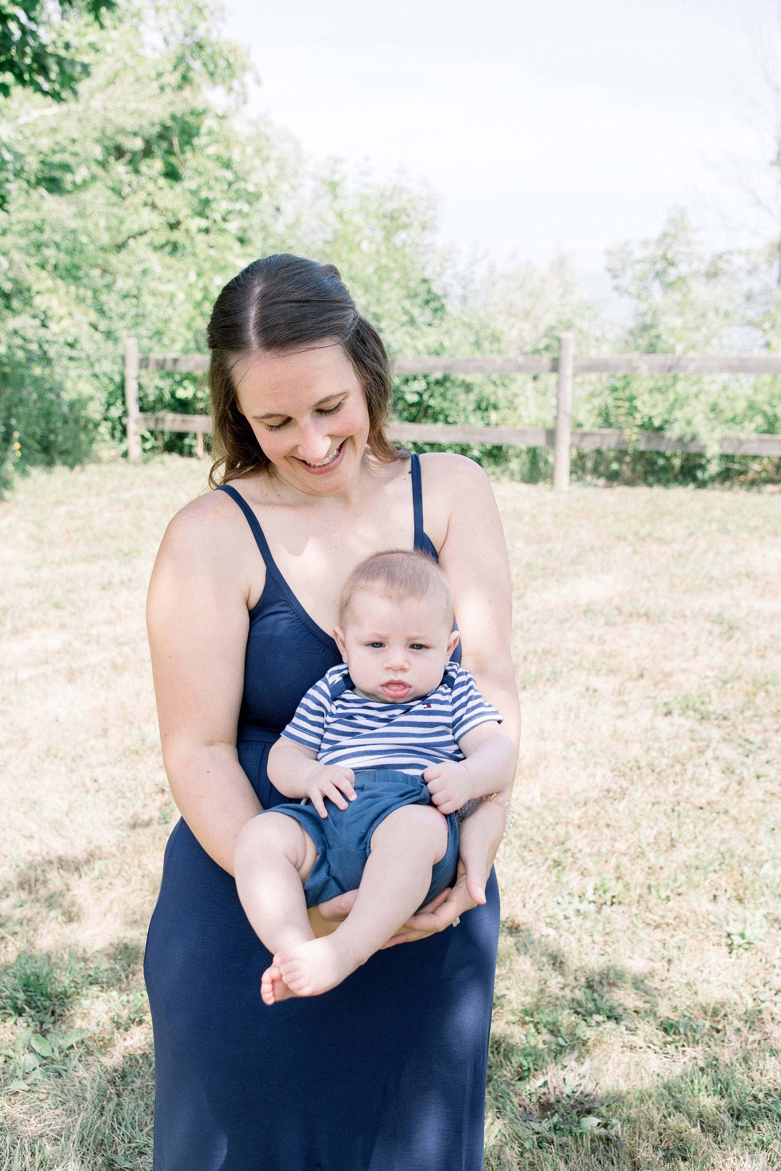 Portrait of mother holding baby boy, looking down at him. Niagara family photographer, Niagara family photography, Niagara portrait photographer, Niagara portrait photography.