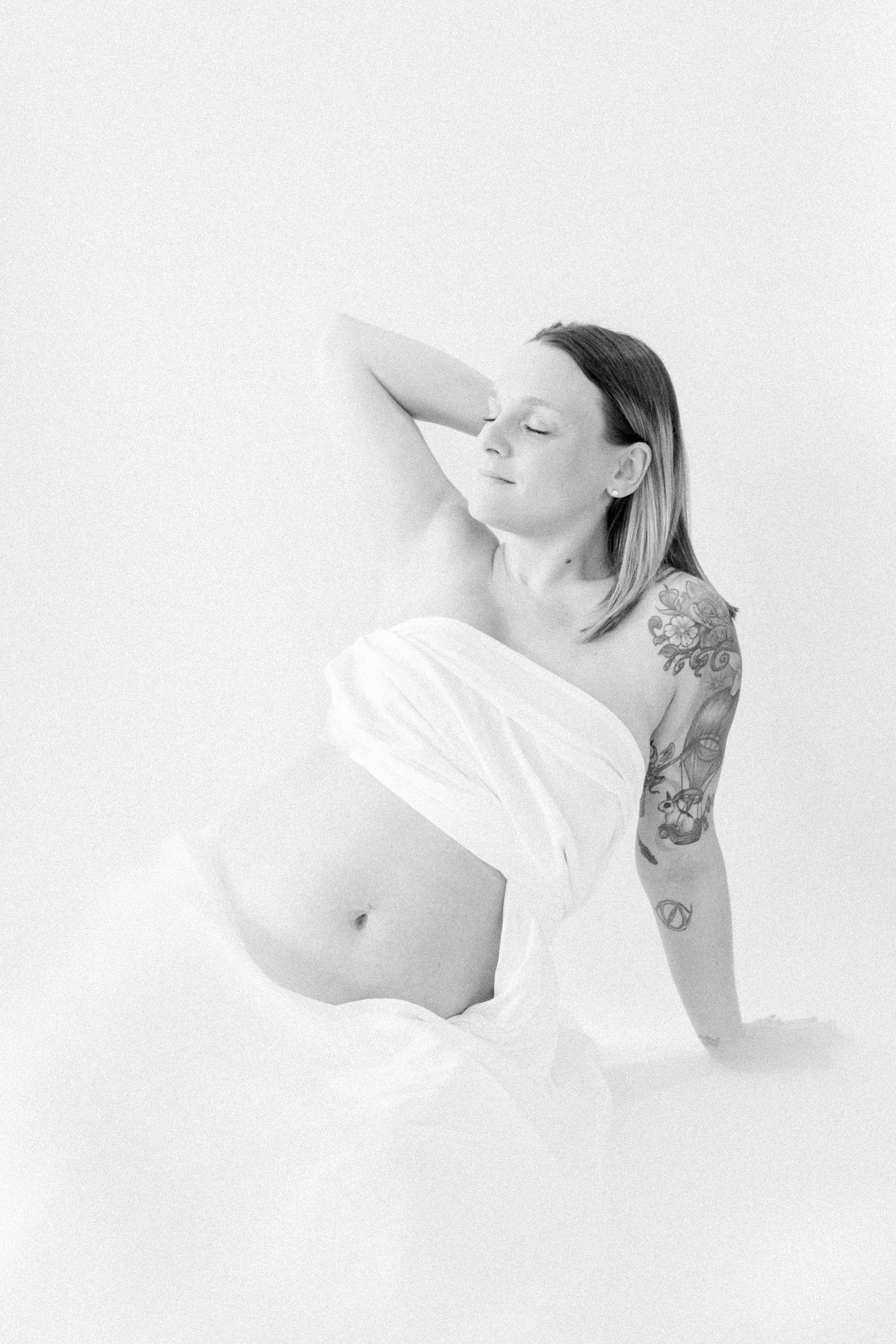Black and white studio portrait of a pregnant mother. Ottawa Maternity Photographer, Montreal Maternity Photographer, Motherhood Photography, Authentic Photography, Light & Airy Photography, Emily VanderBeek Photography.