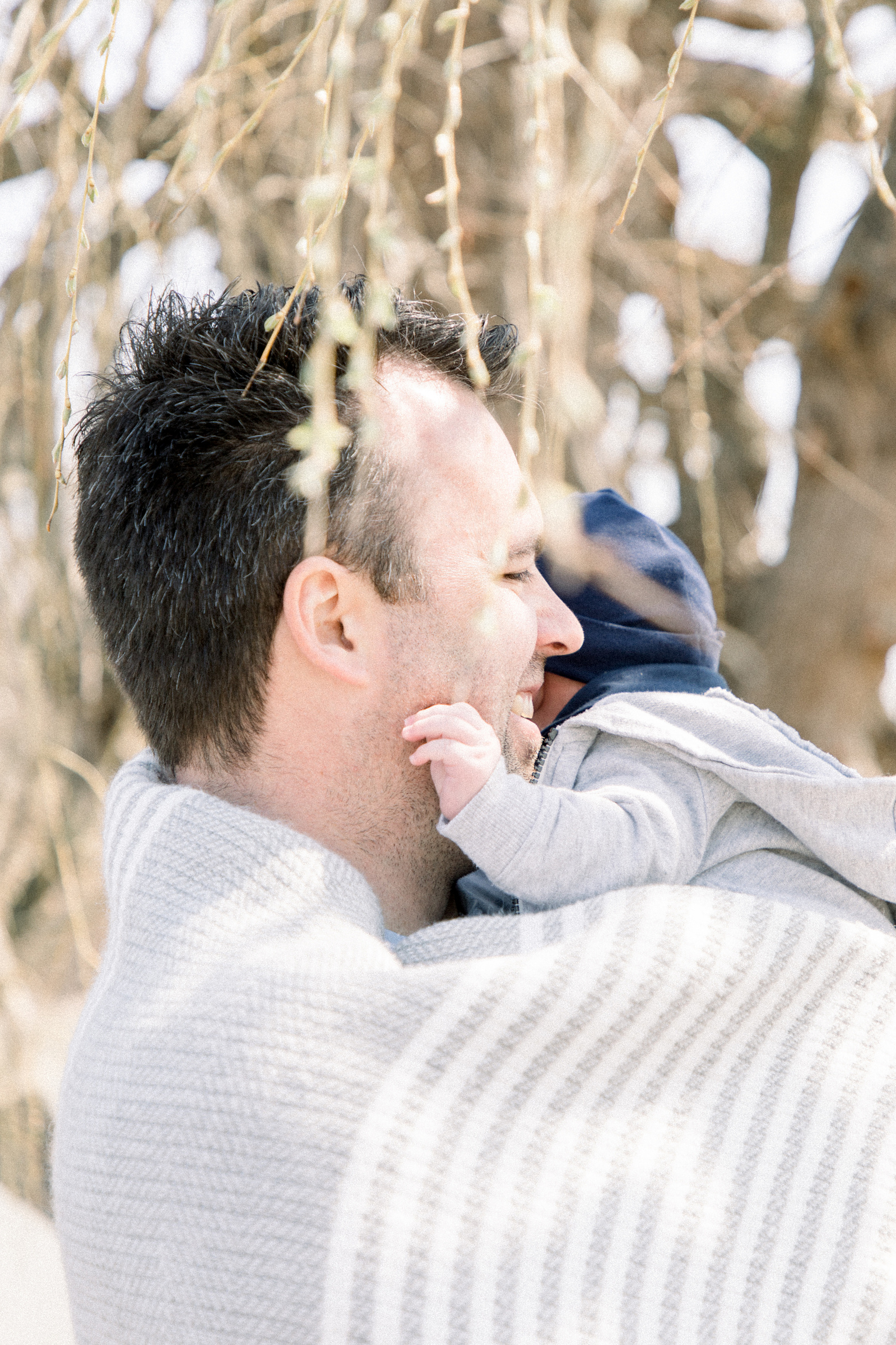 Portrait of a father holding his baby boy, Niagara portrait photographer, Niagara family photographer, family photography, candid photography.