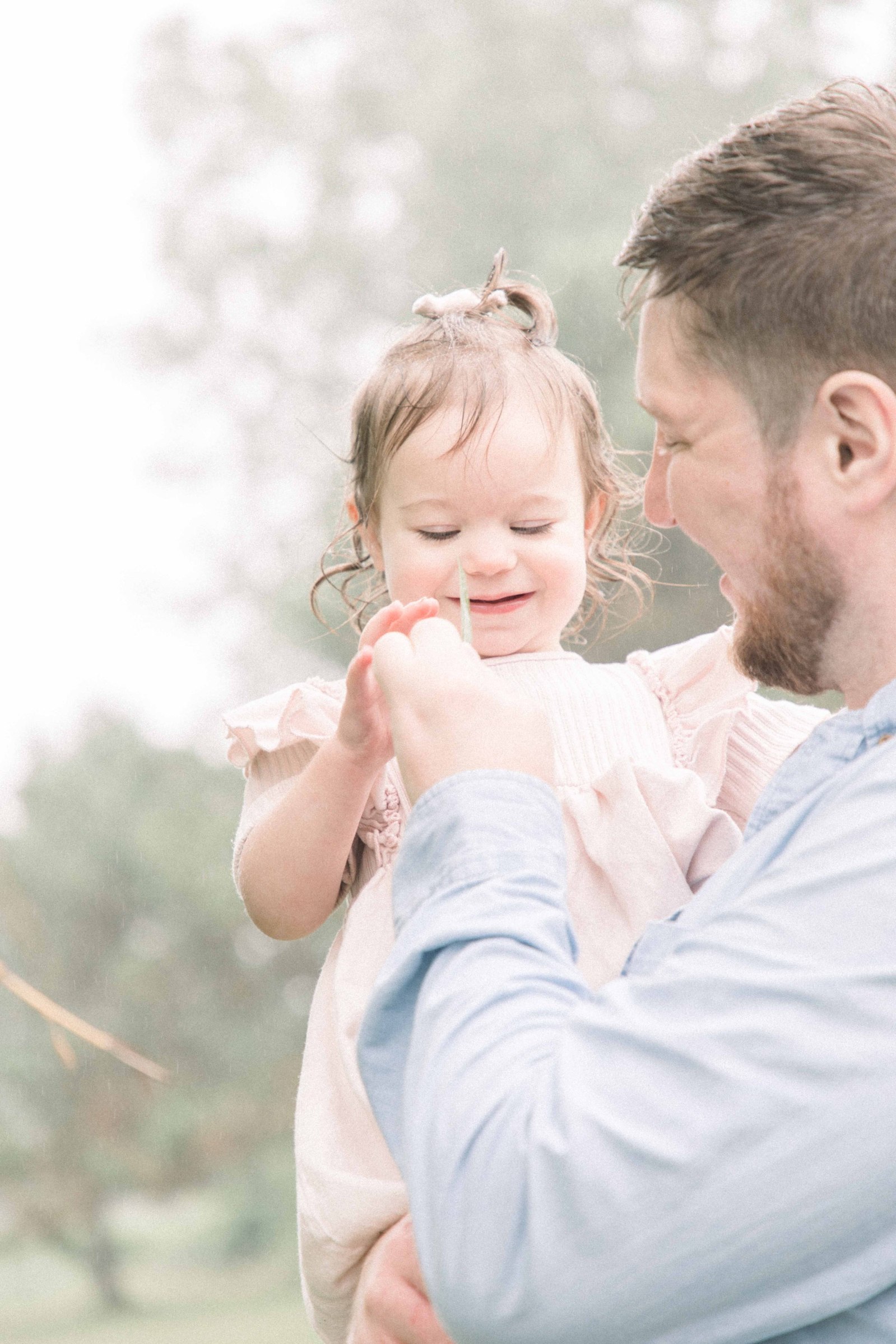 Portrait of father and daughter playing with a leaf and smiling, Niagara Portrait Photographer, Niagara Family Photographer, Niagara Motherhood Photography, Beach Portrait Photography, Emily VanderBeek Photography.