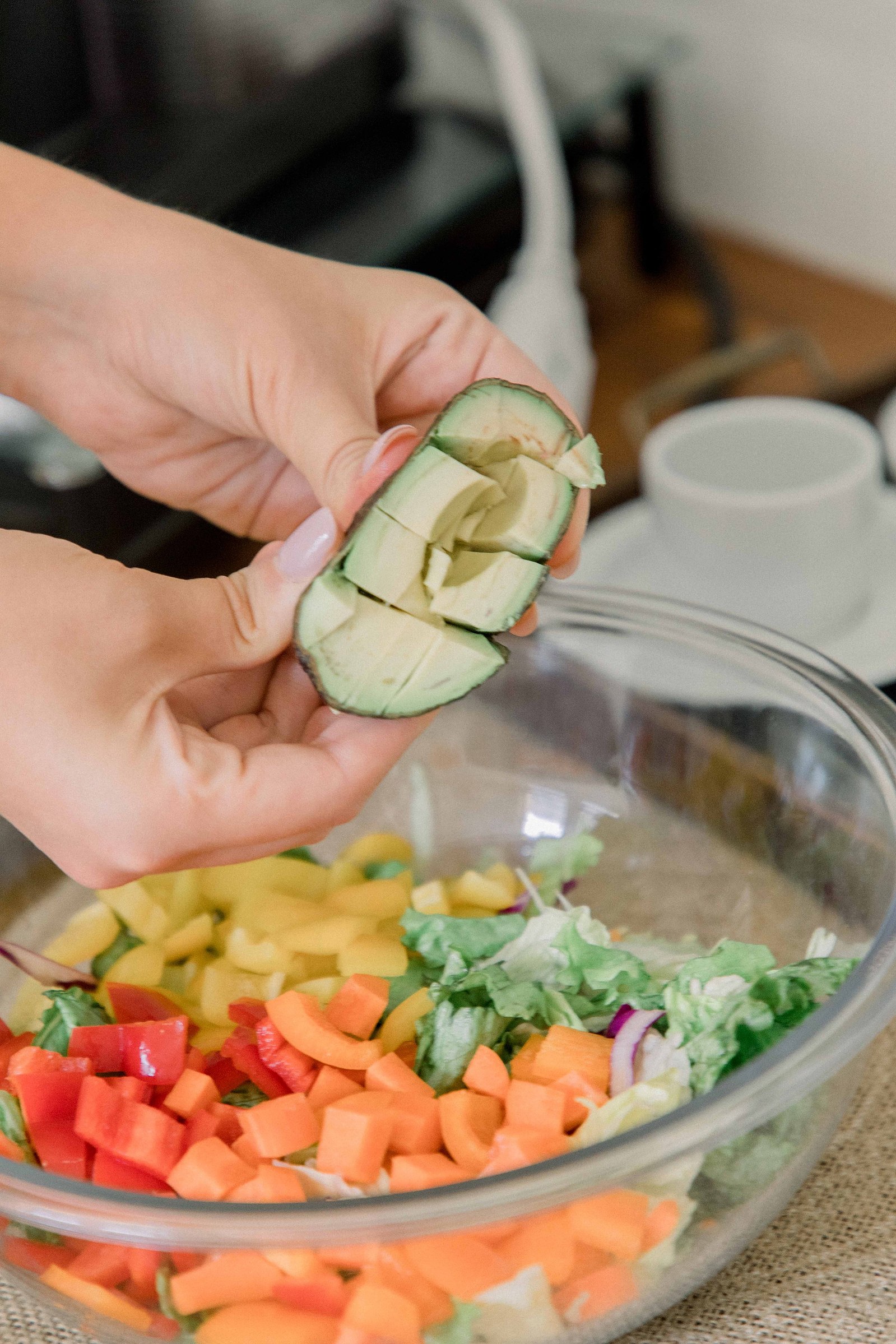 Photo of a woman making a salad in a studio kitchen. Light and airy photography. Emily VanderBeek Photography. Niagara Photographer, Ottawa Photographer, Montreal Photographer.