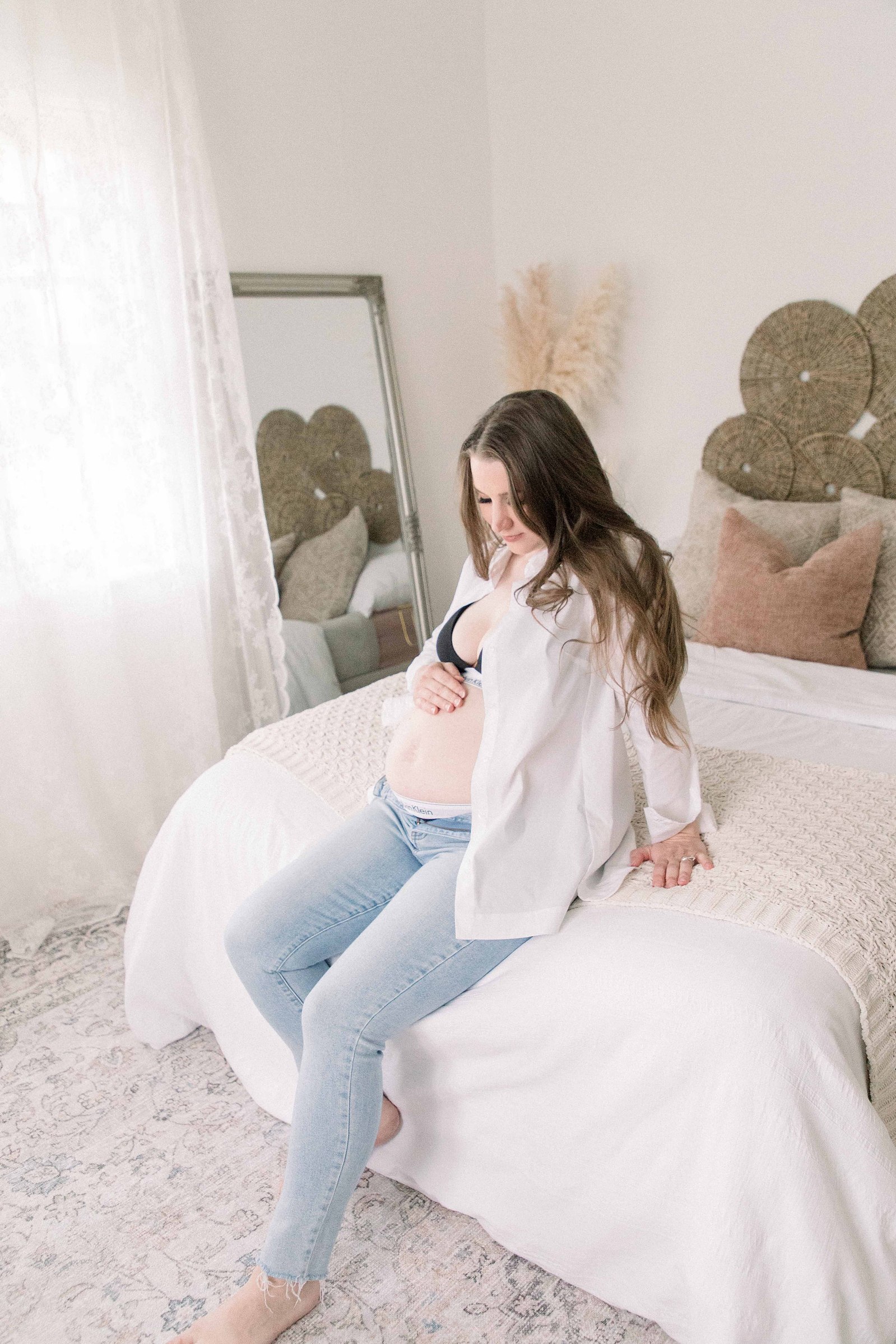 Portrait of a pregnant women holding her belly and looking down at it in a studio. Portrait photography, family photography, motherhood photography, Niagara photographer, Niagara family photography, Vankleek Hill family photography. Emily VanderBeek Photo