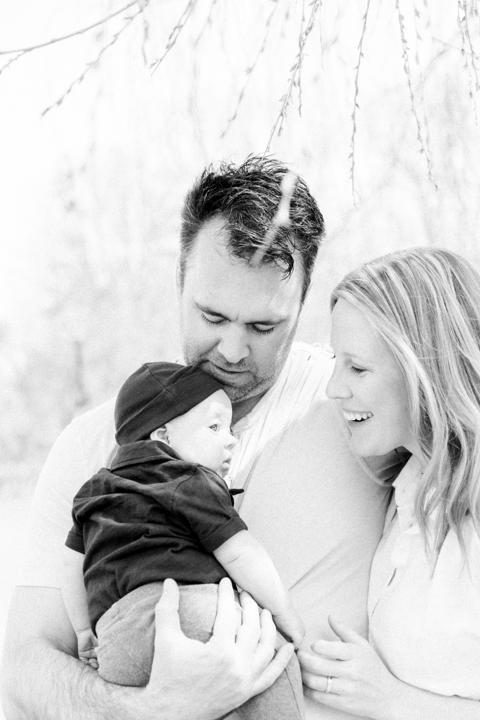Black & white family portrait of baby boy and his parents, Niagara portrait photographer, Niagara family photographer, family photography, candid photography.