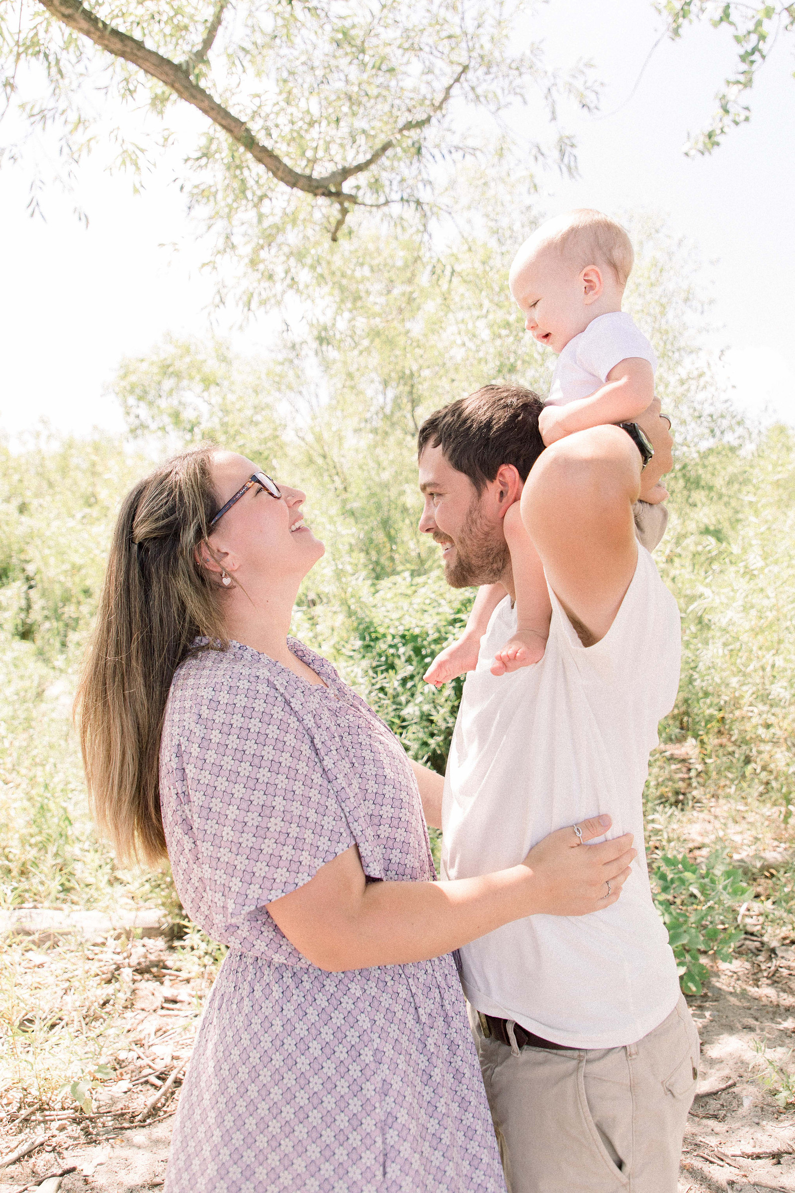 Portrait of family laughing with each other on the beach. Niagara family photographer, Niagara portrait photographer, Niagara motherhood photographer, candid photography, light & airy photography, Emily VanderBeek Photography.
