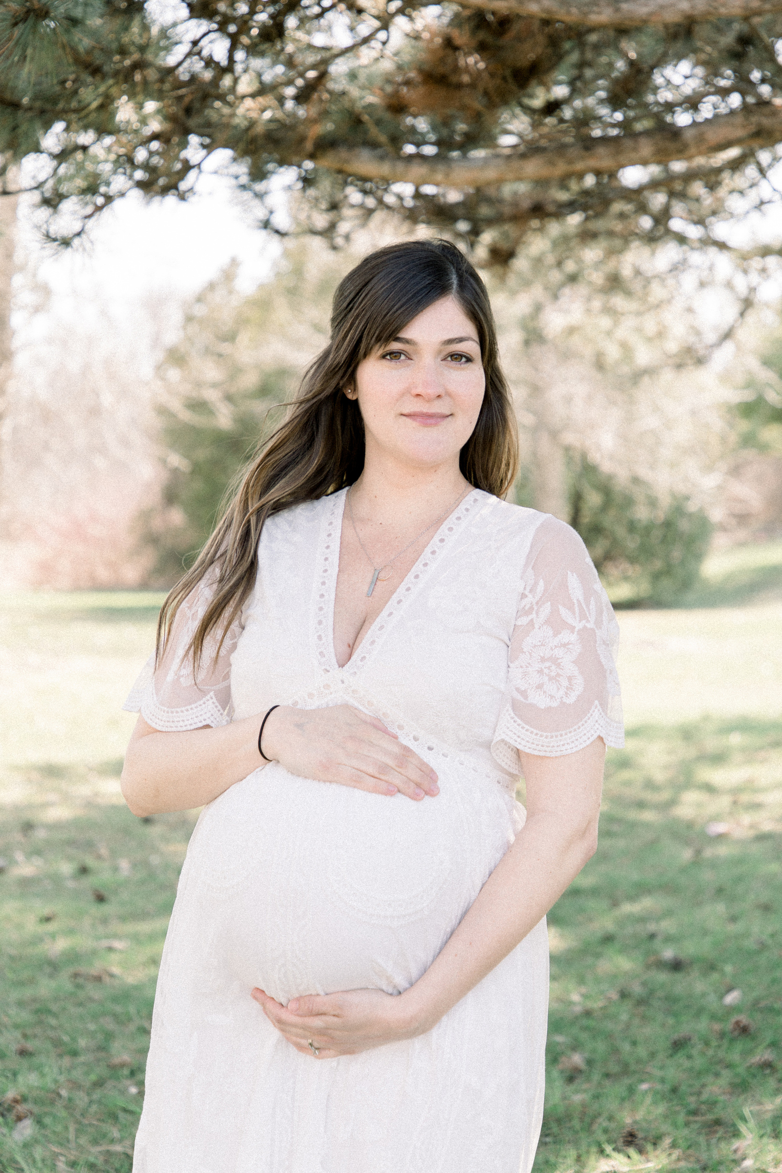 Portrait of an expecting mother holding her belly, Niagara maternity photography, park photo session