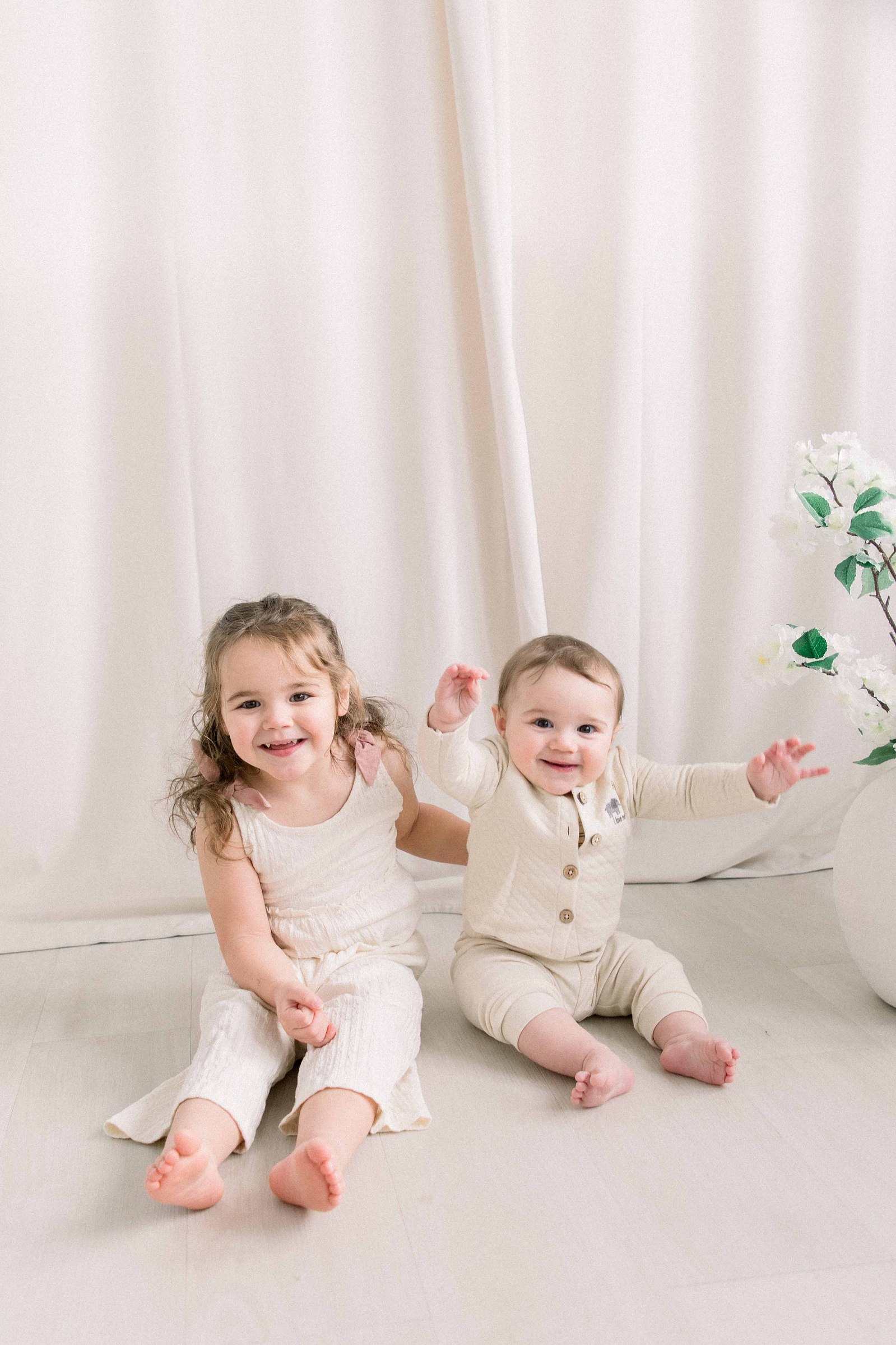 Portrait of siblings in a studio with flowers laughing. Emily VanderBeek Photography. Ottawa family photographer. Candid photography.