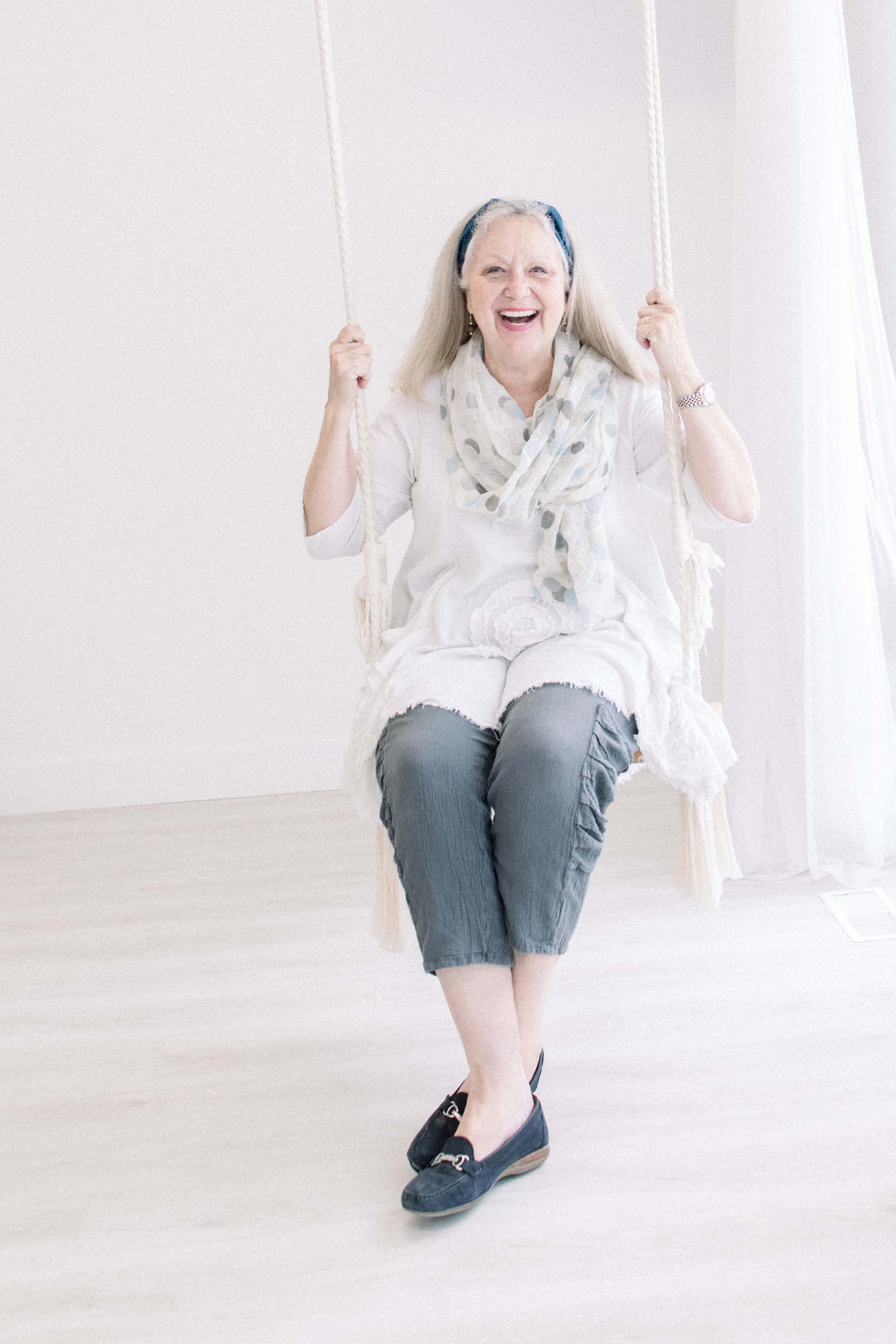 Portrait of woman swinging on swing and laughing. Emily VanderBeek Photography, branding photography, portrait photography, Niagara portrait photographer, Niagara branding photographer.