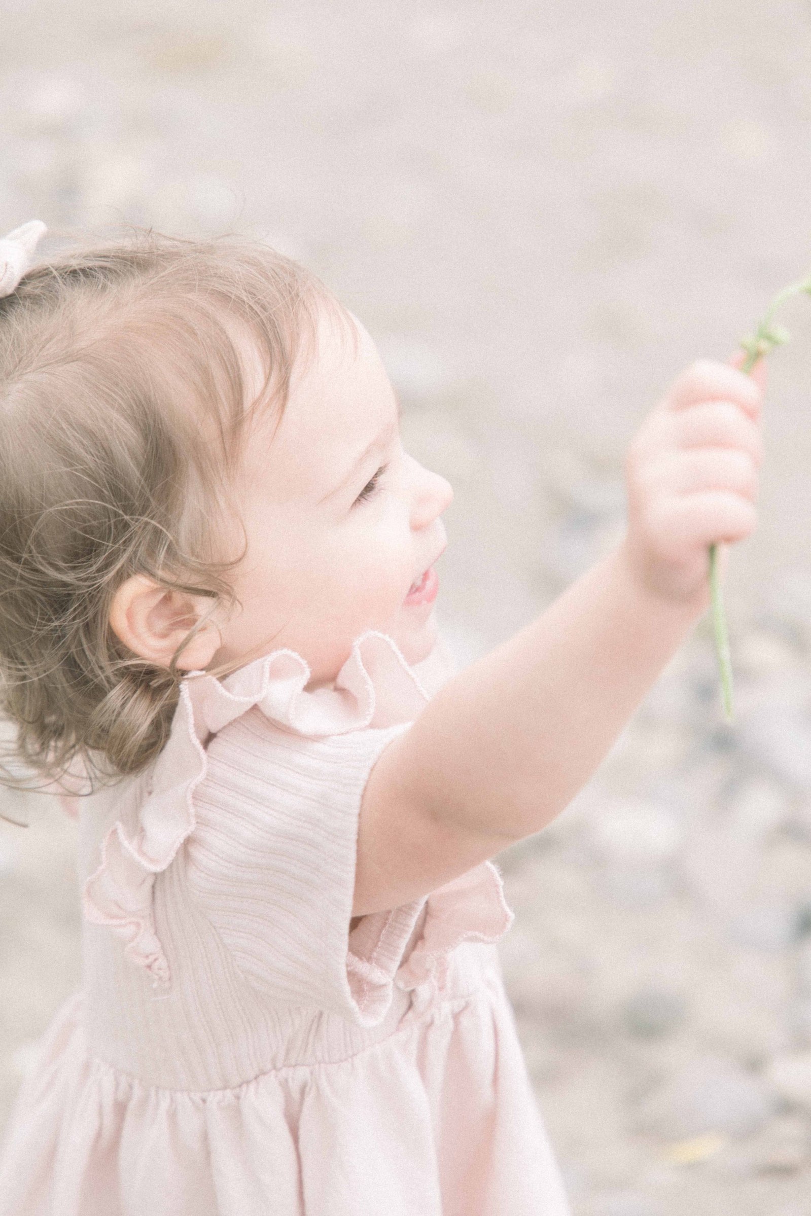 Portrait little girl on the beach holding a flower that she found, Niagara Portrait Photographer, Niagara Family Photographer, Niagara Motherhood Photography, Beach Portrait Photography, Emily VanderBeek Photography.
