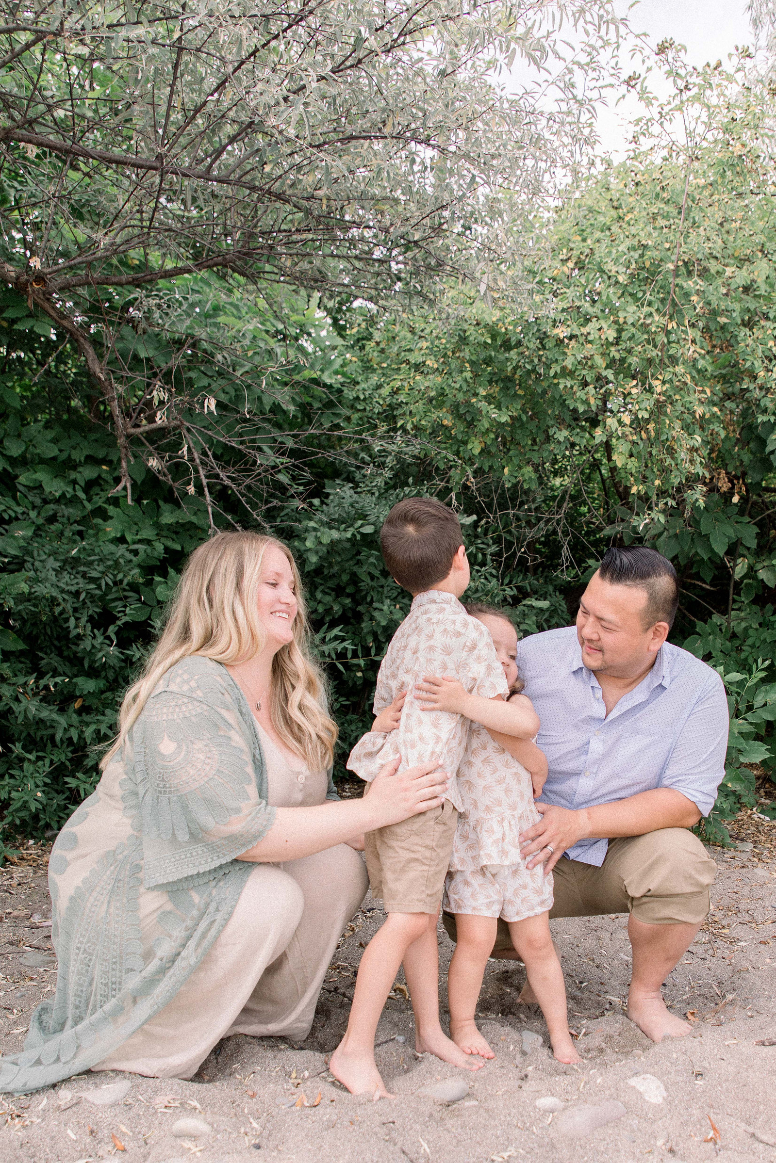 Portrait of family hugging each other on the beach. Niagara family photographer, Niagara portrait photographer, Niagara motherhood photographer, candid photography, light & airy photography, Emily VanderBeek Photography.