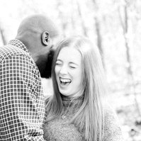 Black and white candid portrait of man hugging woman and her laughing Emily VanderBeek Photography, Portrait and Family photography, Niagara Photographer, Champlain Photographer, Vaudreuil-Soulanges Photographer, candid photography, authentic photography.