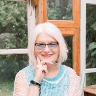 Portrait of woman sitting in a greenhouse smiling into the camera, Emily VanderBeek Photography, Portrait and Family photography, Niagara Photographer, Champlain Photographer, Vaudreuil-Soulanges Photographer, candid photography, authentic photography.