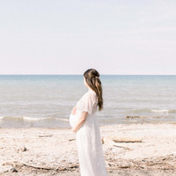 Maternity photo of woman holding bump on the beach, Emily VanderBeek Photography, Portrait and Family photography, Niagara Photographer, Champlain Photographer, Vaudreuil-Soulanges Photographer, candid photography, authentic photography.