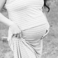 Black and white maternity photo of woman holding her pregnant belly, Emily VanderBeek Photography, Portrait and Family photography, Niagara Photographer, Champlain Photographer, Vaudreuil-Soulanges Photographer, candid photography, authentic photography.