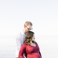 Maternity photo of man hugging woman from behind on beach, Emily VanderBeek Photography, Portrait and Family photography, Niagara Photographer, Champlain Photographer, Vaudreuil-Soulanges Photographer, candid photography, authentic photography.