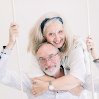 Photo of older couple on studio swing smiling at the camera, Emily VanderBeek Photography, Portrait and Family photography, Niagara Photographer, Champlain Photographer, Vaudreuil-Soulanges Photographer, candid photography, authentic photography.