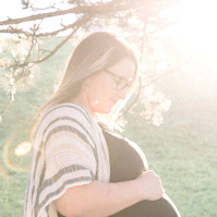 Maternity photo of woman looking at her bump at sunset, Emily VanderBeek Photography, Portrait and Family photography, Niagara Photographer, Champlain Photographer, Vaudreuil-Soulanges Photographer, candid photography, authentic photography.