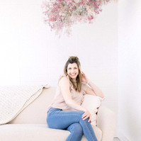 Woman sitting on couch in studio smiling into the camera, Emily VanderBeek Photography, Portrait and Family photography, Niagara Photographer, Champlain Photographer, Vaudreuil-Soulanges Photographer, candid photography, authentic photography.