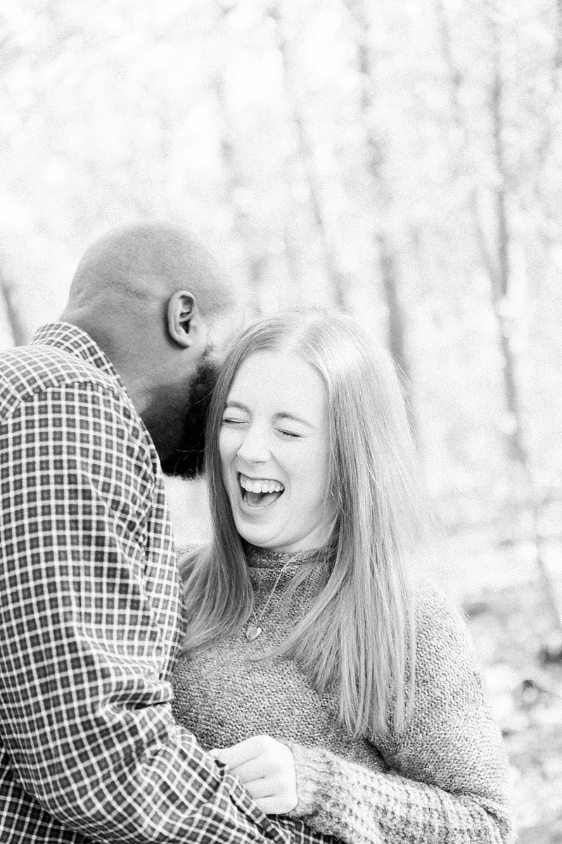 Black and white candid portrait of man hugging woman and her laughing Emily VanderBeek Photography, Portrait and Family photography, Niagara Photographer, Champlain Photographer, Vaudreuil-Soulanges Photographer, candid photography, authentic photography.