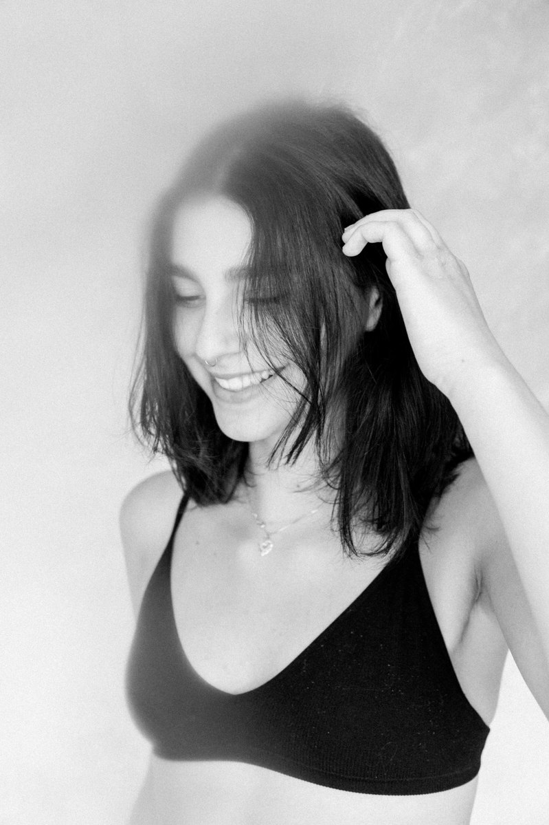 Black and white portrait of a women looking down and smiling, Emily VanderBeek Photography, Portrait and Family photography, Niagara Photographer, Champlain Photographer, Vaudreuil-Soulanges Photographer, candid photography, authentic photography.