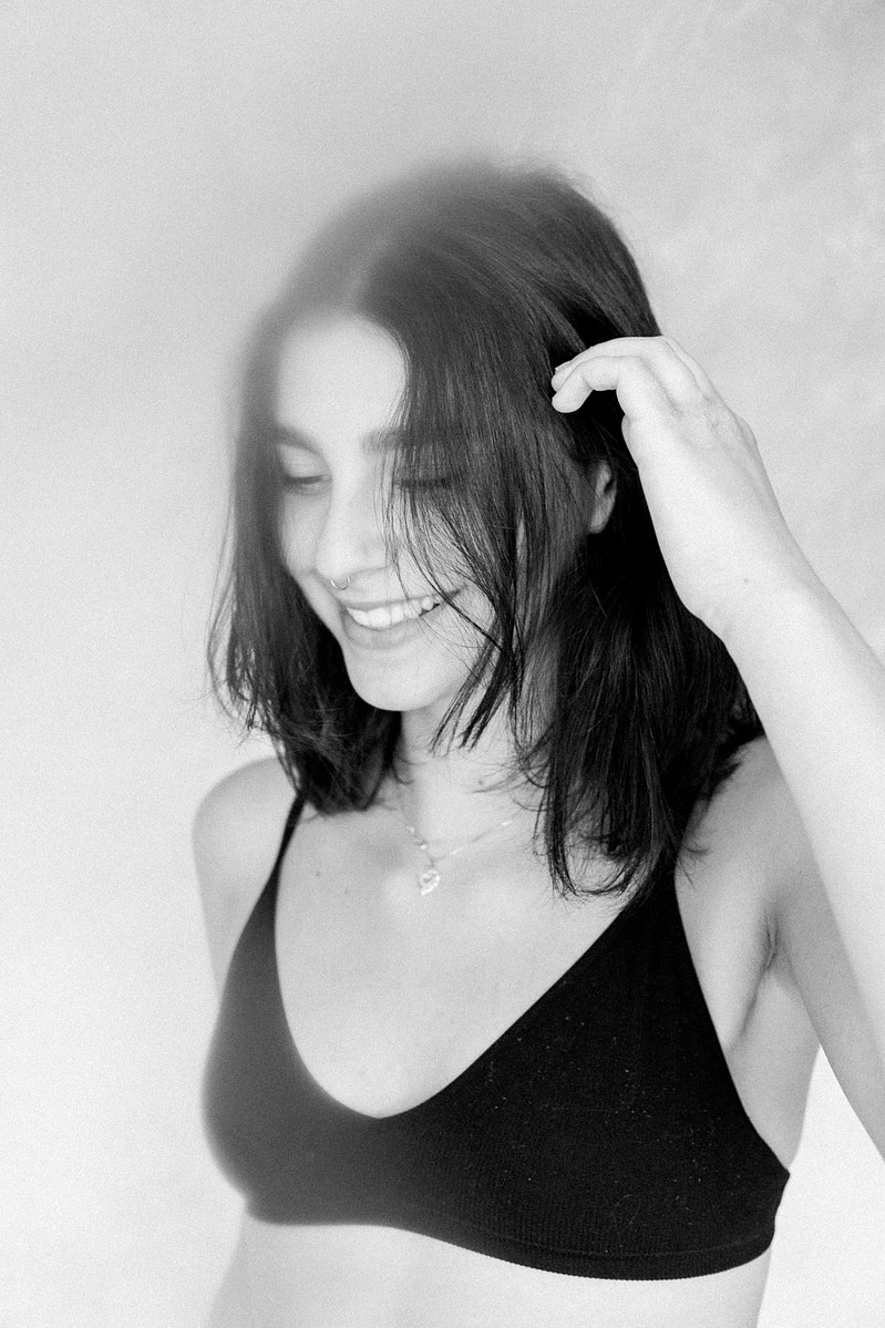 Black and white portrait of a women looking down and smiling, Emily VanderBeek Photography, Portrait and Family photography, Niagara Photographer, Champlain Photographer, Vaudreuil-Soulanges Photographer, candid photography, authentic photography.