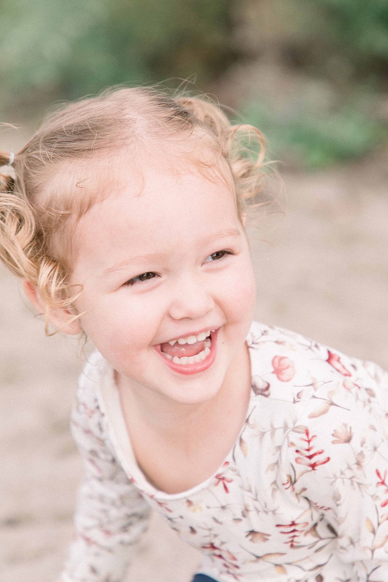 Candid portrait of little girl laughing on the beach, Emily VanderBeek Photography, Portrait and Family photography, Niagara Photographer, Champlain Photographer, Vaudreuil-Soulanges Photographer, candid photography, authentic photography.