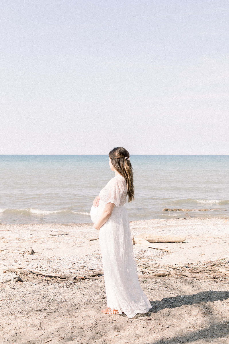 Maternity photo of woman holding bump on the beach, Emily VanderBeek Photography, Portrait and Family photography, Niagara Photographer, Champlain Photographer, Vaudreuil-Soulanges Photographer, candid photography, authentic photography.