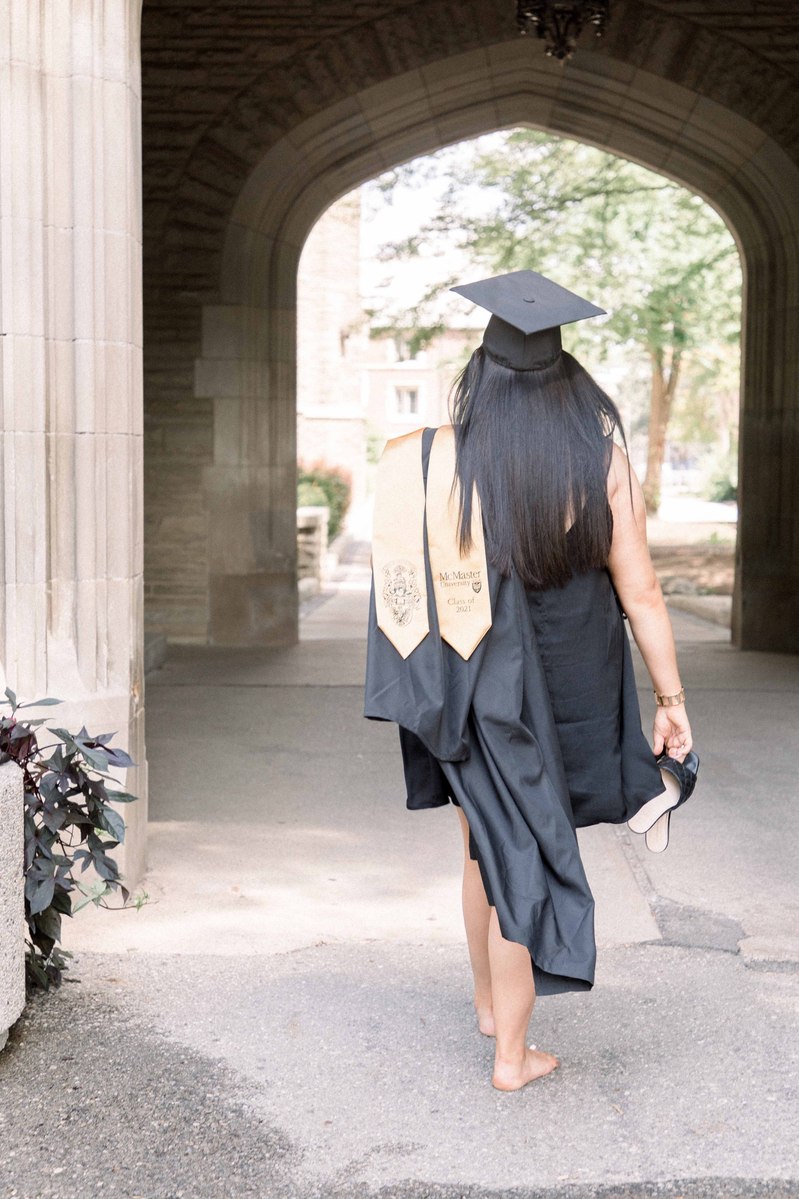 Graduation photo of woman walking away with her sash and gown showing Emily VanderBeek Photography, Portrait and Family photography, Niagara Photographer, Champlain Photographer, Vaudreuil-Soulanges Photographer, candid photography, authentic photography.