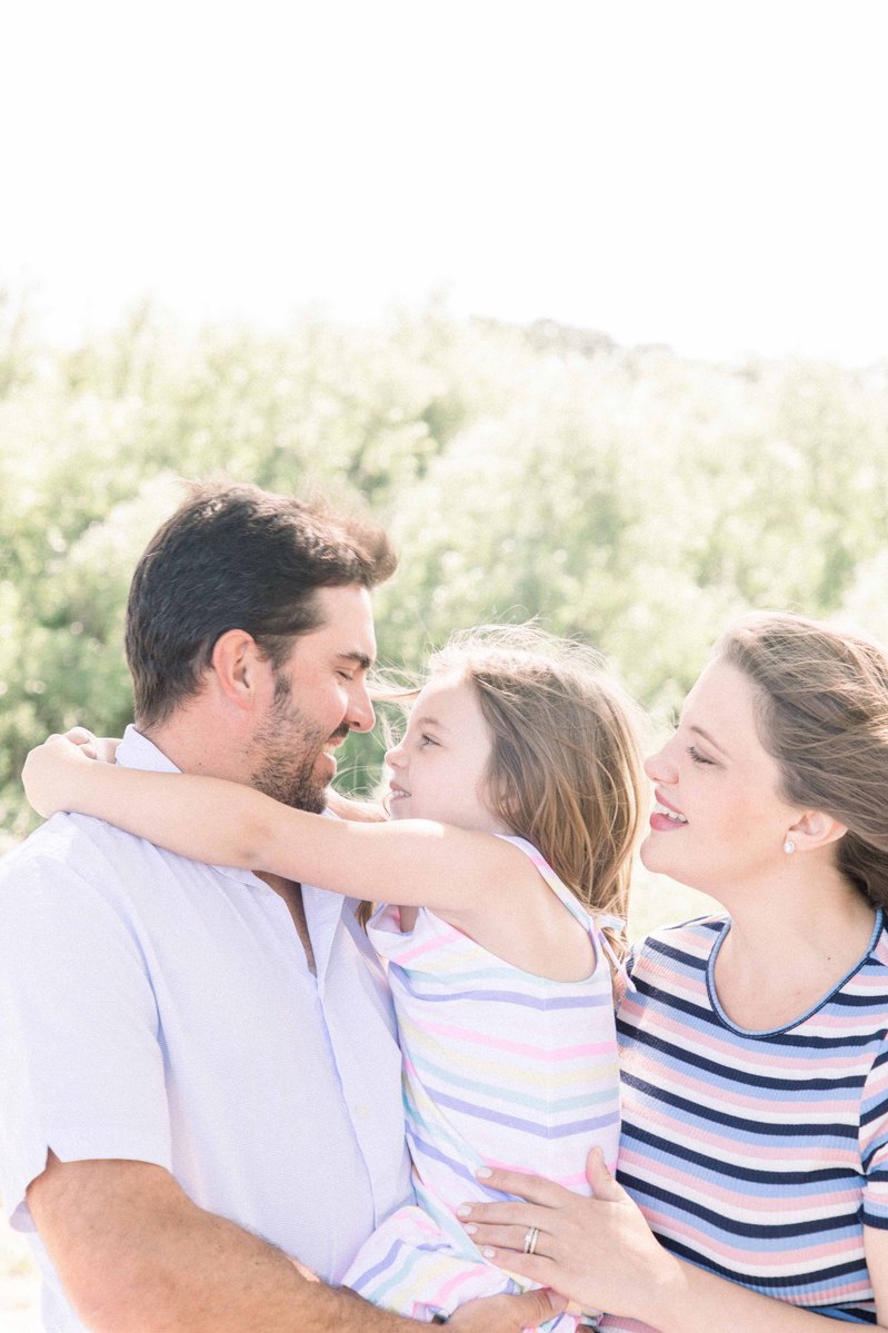 Candid portrait of family of three with little girl in the middle, Emily VanderBeek Photography, Portrait and Family photography, Niagara Photographer, Champlain Photographer, Vaudreuil-Soulanges Photographer, candid photography, authentic photography.