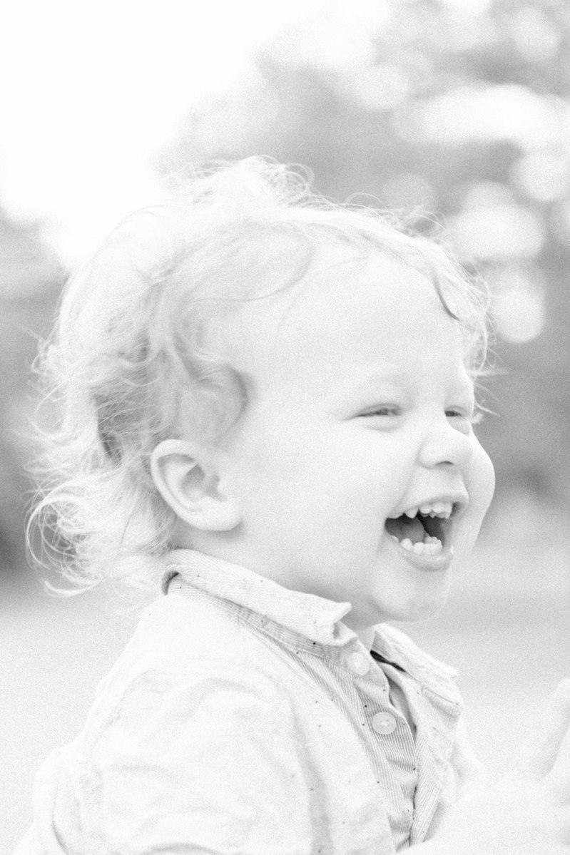 Black and white candid photo of little boy laughing, Emily VanderBeek Photography, Portrait and Family photography, Niagara Photographer, Champlain Photographer, Vaudreuil-Soulanges Photographer, candid photography, authentic photography.