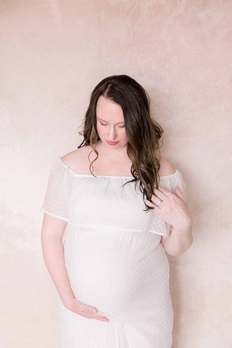Maternity photo of woman in studio holding her pregnant belly, Emily VanderBeek Photography, Portrait and Family photography, Niagara Photographer, Champlain Photographer, Vaudreuil-Soulanges Photographer, candid photography, authentic photography.