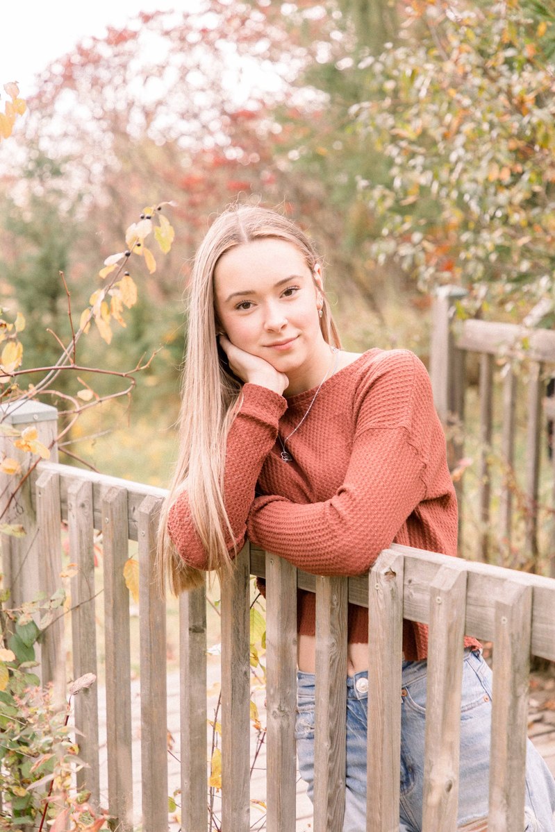 Portrait of woman on a bridge with a beautiful fall background. Emily VanderBeek Photography, Portrait and Family photography, Niagara Photographer, Champlain Photographer, Vaudreuil-Soulanges Photographer, candid photography, authentic photography.