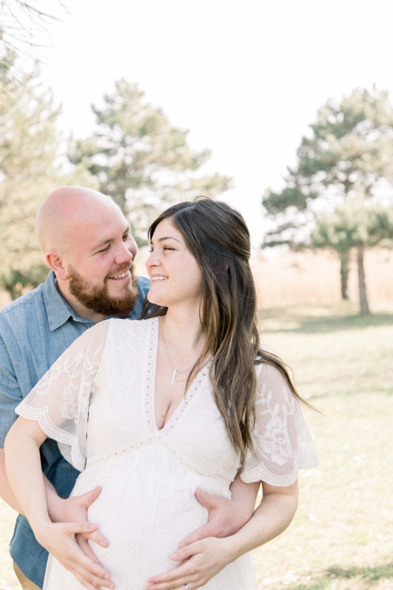 Maternity photo of man and woman looking at each other laughing, Emily VanderBeek Photography, Portrait and Family photography, Niagara Photographer, Champlain Photographer, Vaudreuil-Soulanges Photographer, candid photography, authentic photography.