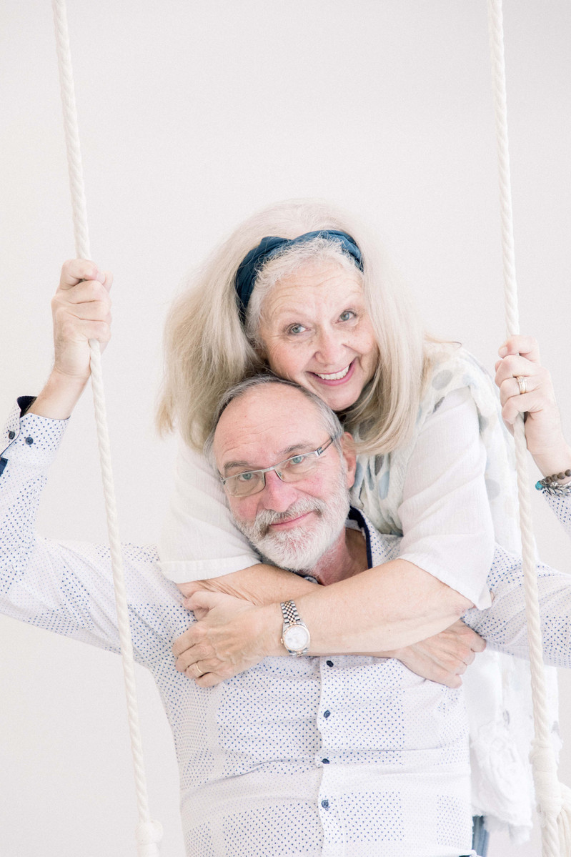 Photo of older couple on studio swing smiling at the camera, Emily VanderBeek Photography, Portrait and Family photography, Niagara Photographer, Champlain Photographer, Vaudreuil-Soulanges Photographer, candid photography, authentic photography.