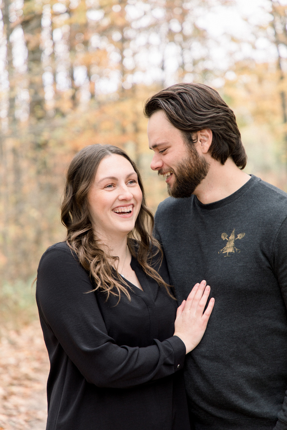 Portrait of couple, man whispering secret to woman, woman laughing. Niagara portrait photography, Niagara portrait photographer, Niagara family photography, Niagara family photographer.