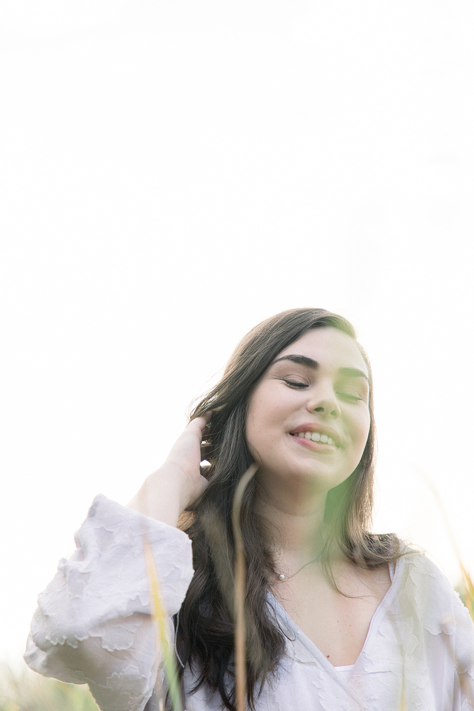 Close-up portrait of woman playing with her hair with her eyes closed. Niagara portrait photography, Niagara portrait photographer, Niagara branding photography, Niagara branding photographer.