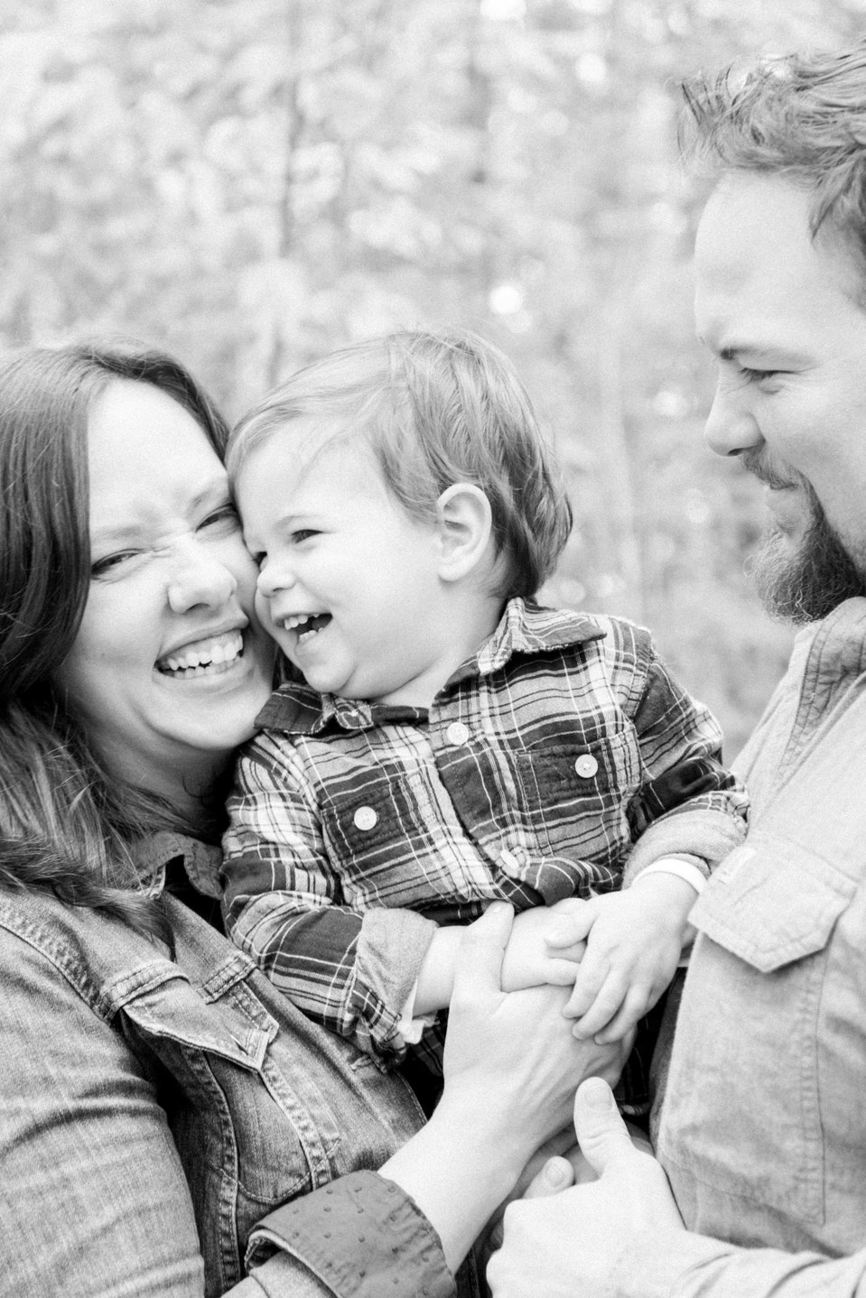 Black and white portrait of family of three with little boy laughing at mother, Fall photos, Niagara family photographer, family photography, Niagara portrait photographer, portrait photography, Emily VanderBeek Photography.