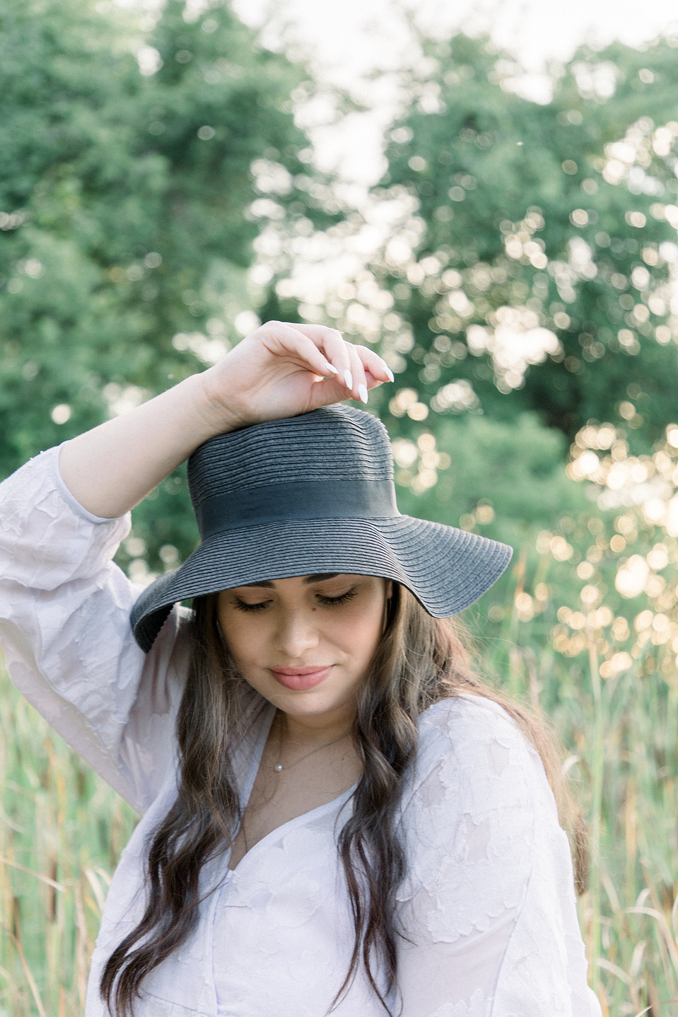 Close-up portrait of woman wearing hat looking down at the ground. Niagara portrait photography, Niagara portrait photographer, Niagara branding photography, Niagara branding photographer.