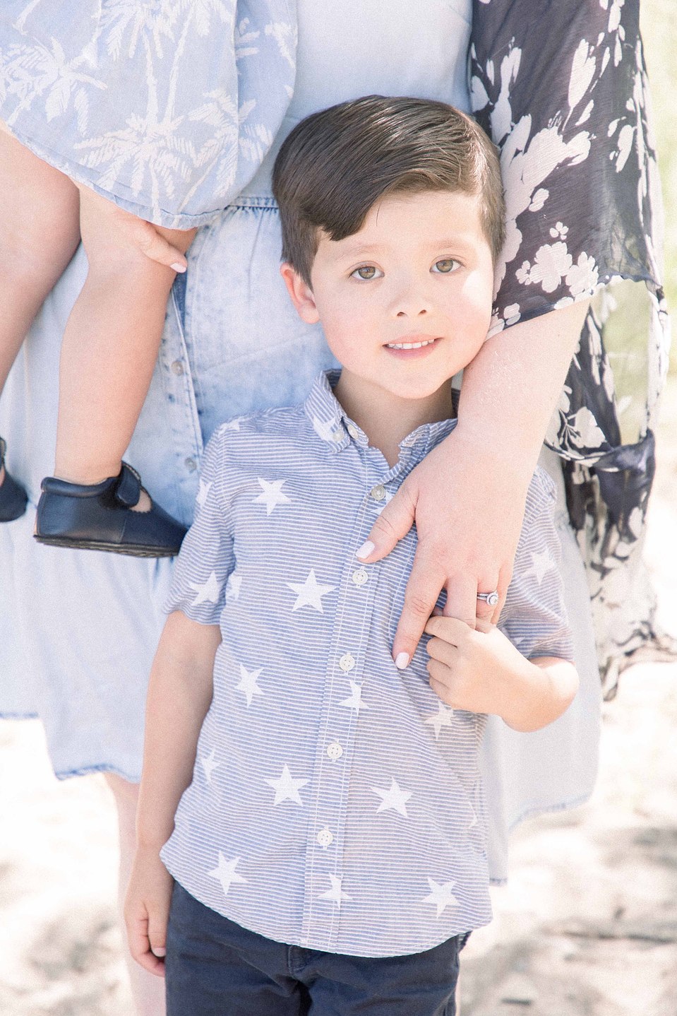 Portrait of little boy smiling at the camera while standing on the beach, Niagara portrait photographer, Niagara family photographer, portrait photography, family photography, candid photography, authentic photography, Emily VanderBeek Photography.