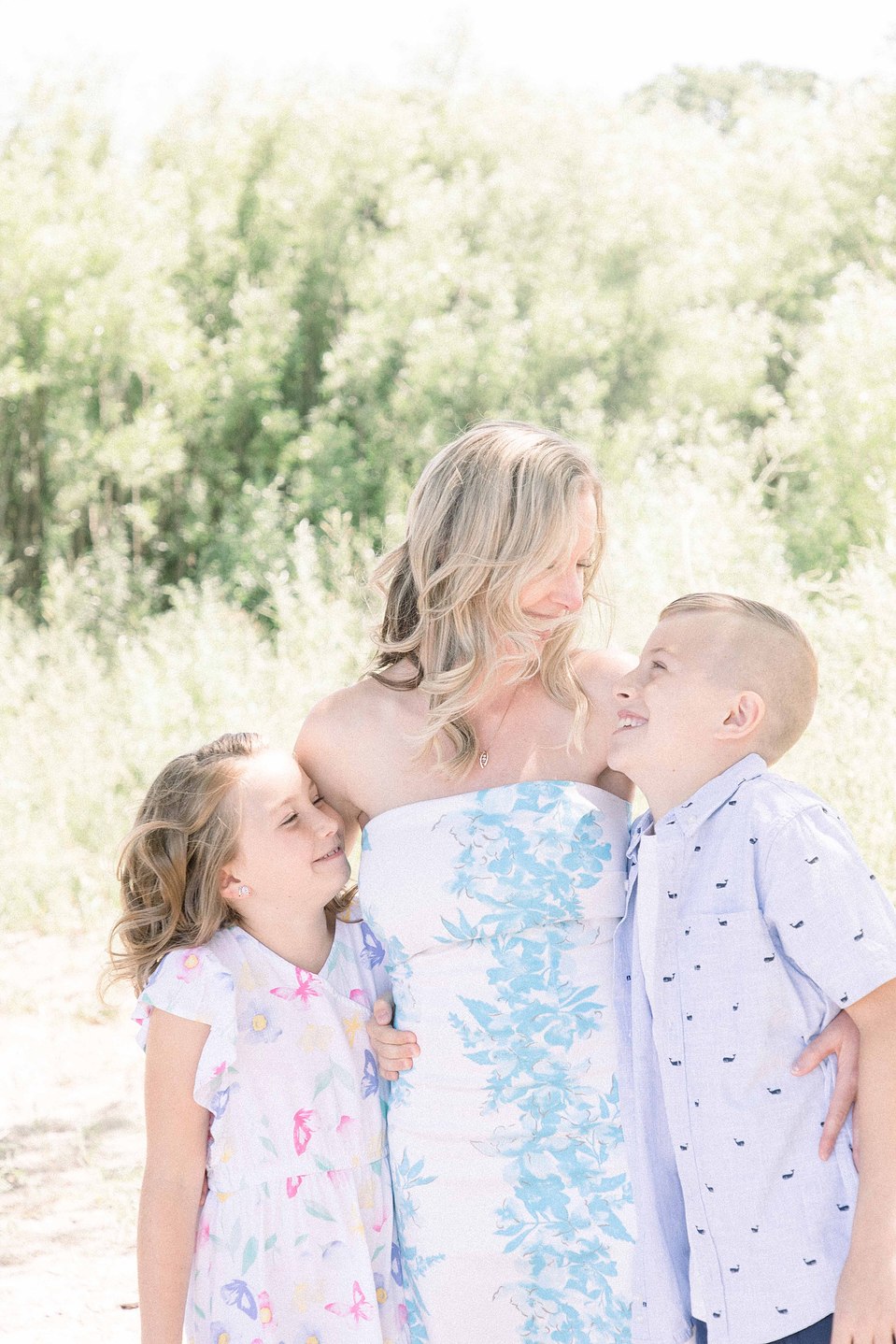Portrait of mother and two kids smiling at each other on the beach, Niagara portrait photographer, Niagara family photographer, portrait photography, family photography, candid photography, authentic photography, Emily VanderBeek Photography.