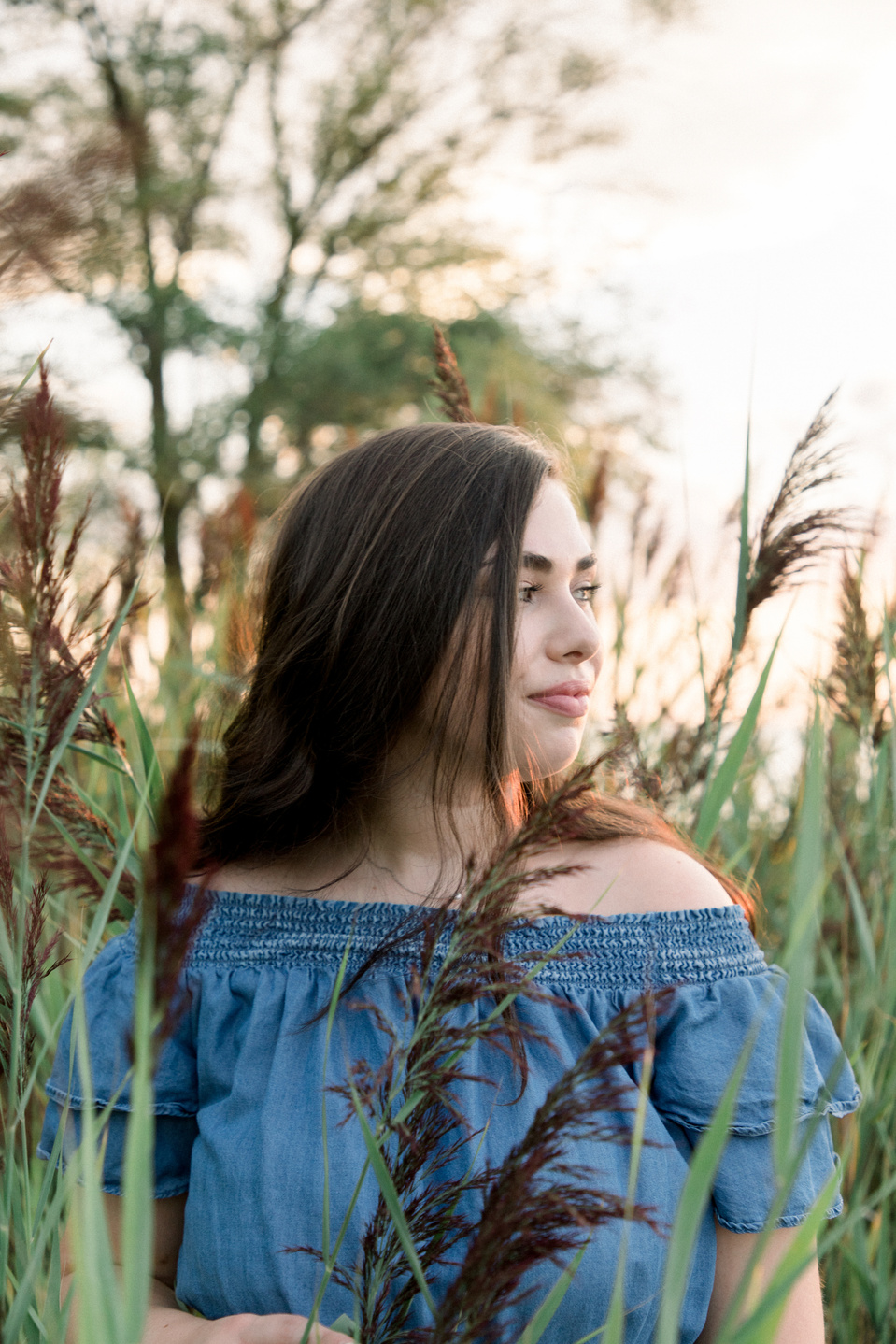 Full portrait of woman amongst tall grass, looking off into the distance. Niagara portrait photography, Niagara portrait photographer, Niagara branding photography, Niagara branding photographer.