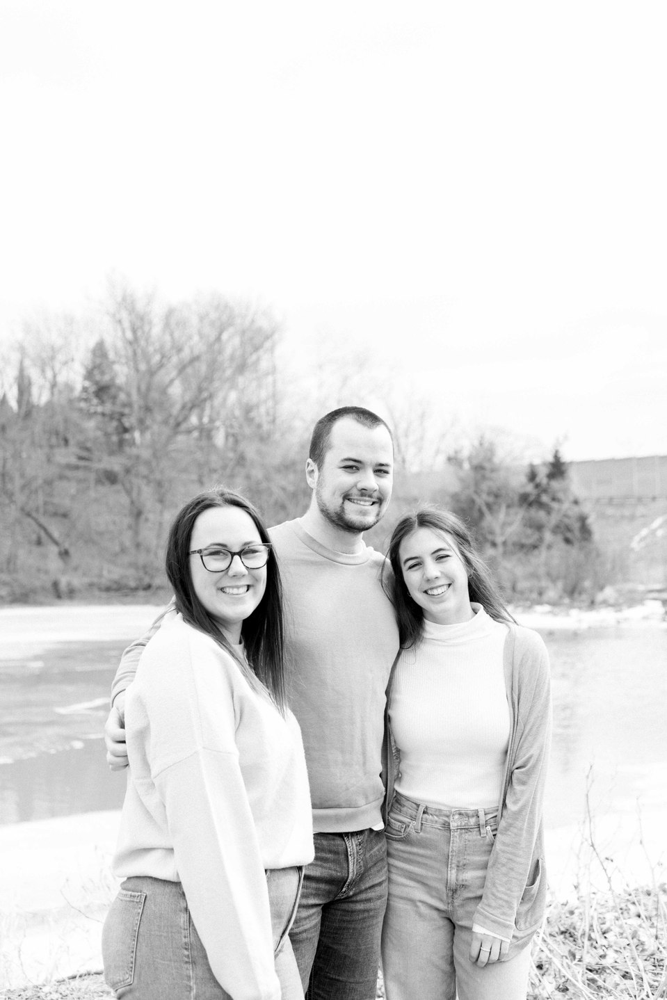 Black and white photo of three siblings by the water, Niagara family photographer, family photography, Niagara portrait photographer, portrait photography, Emily VanderBeek Photography.
